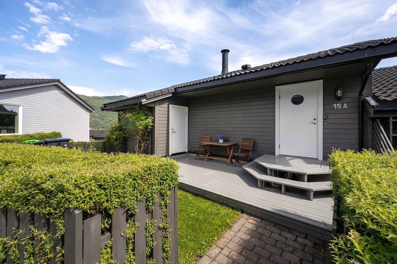Pent opparbeidet inngangsparti med terrasse og utebod. Galleribilde