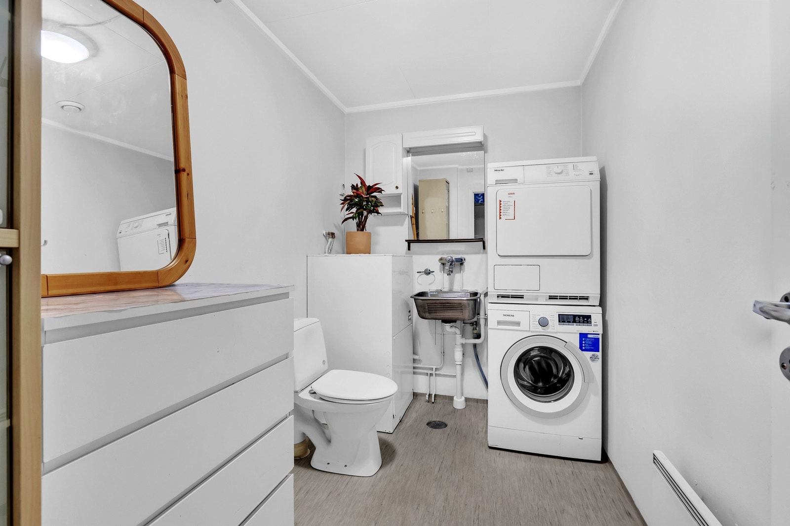 Vaskerommet er utstyrt med opplegg for vaskemaskin, praktisk vaskekar, gulvstående toalett og varmtvannsbereder. Galleribilde