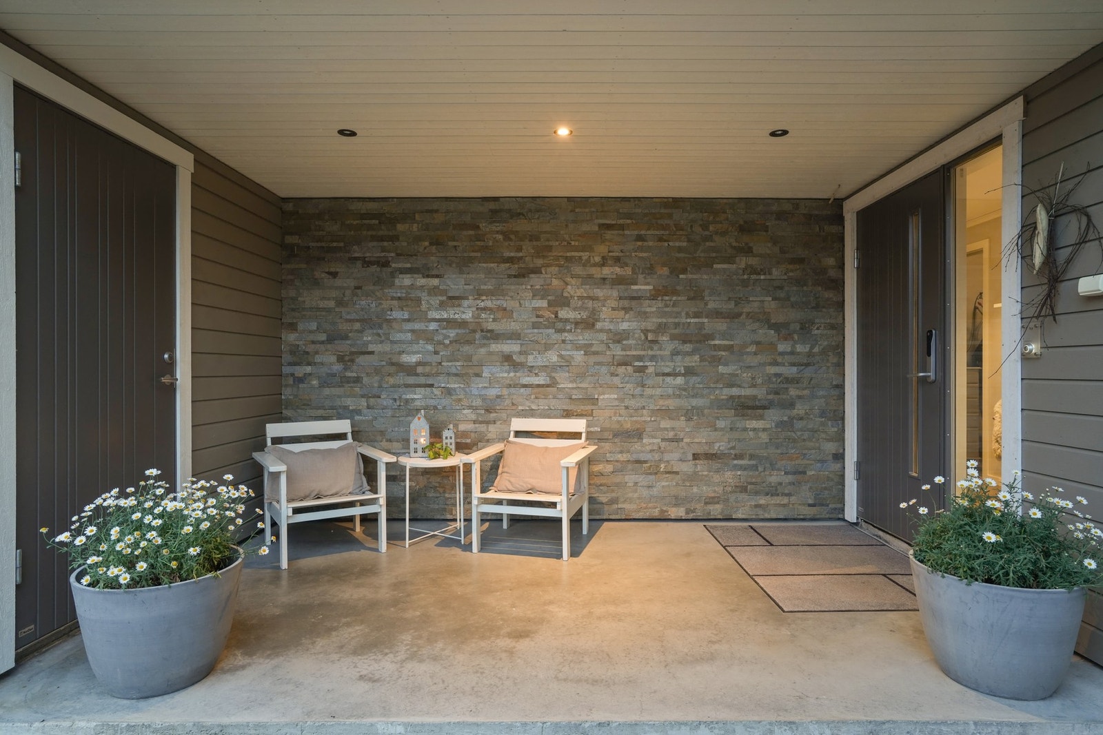 Velkommen hjem! Et overbygd inngangsparti med eksklusiv skifervegg og enkel adkomst til garasjen - her går du alltid tørrskodd fra bil til bolig. Galleribilde