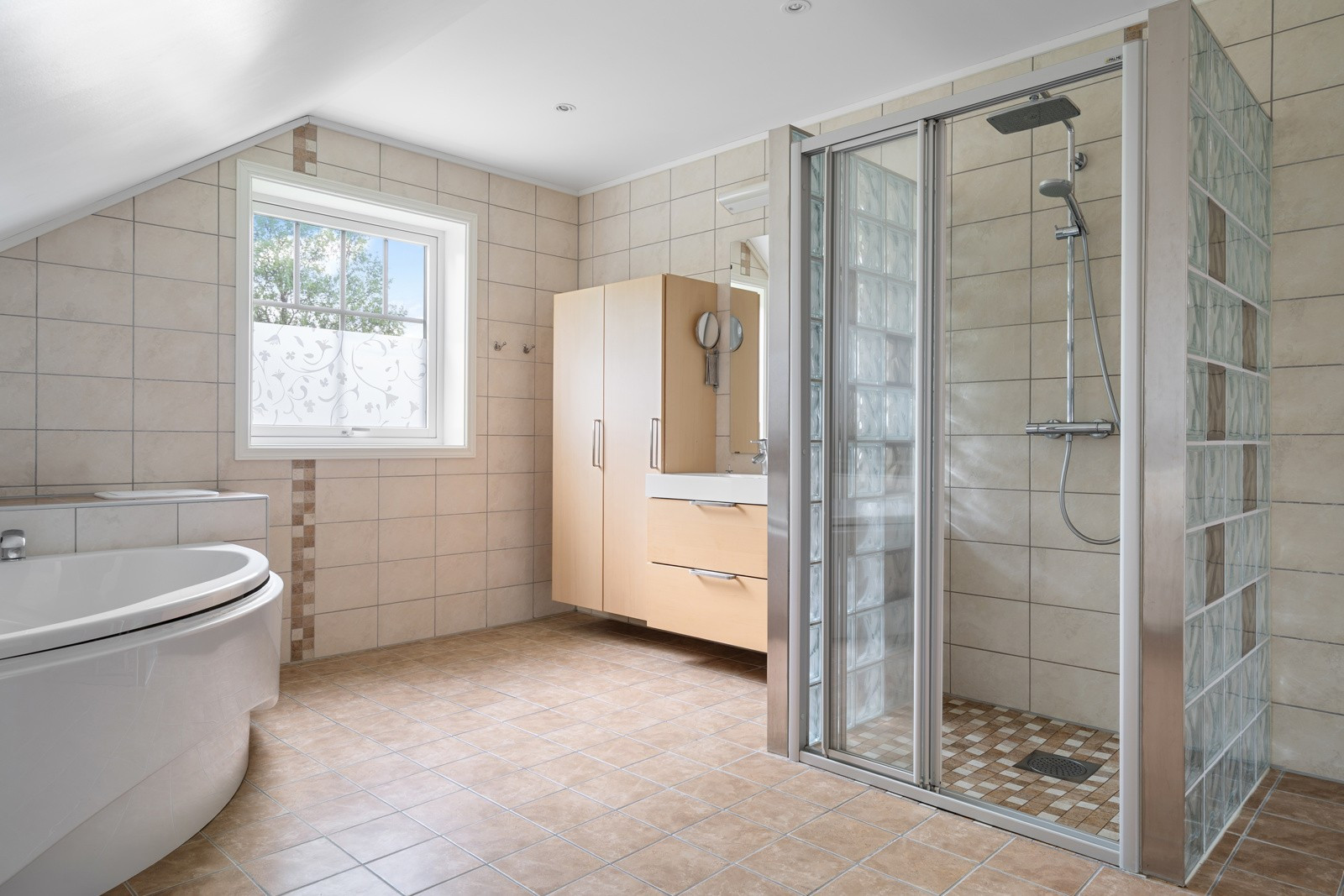 Badet har dusj og hjørnebadekar. Det er også etablert en sluse for skittentøy (ved vindu) som går rett ned til vaskerom - Praktisk og ryddig!