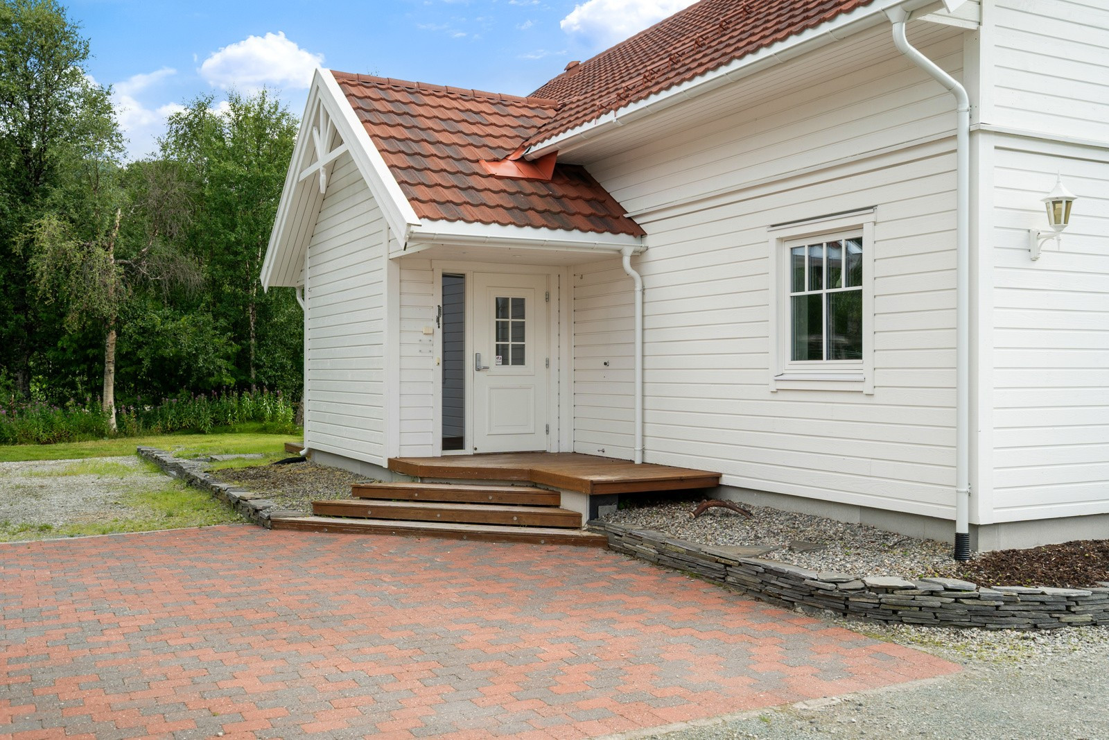 Innbydende inngang og brosteinsbelagt gårdsplass.
