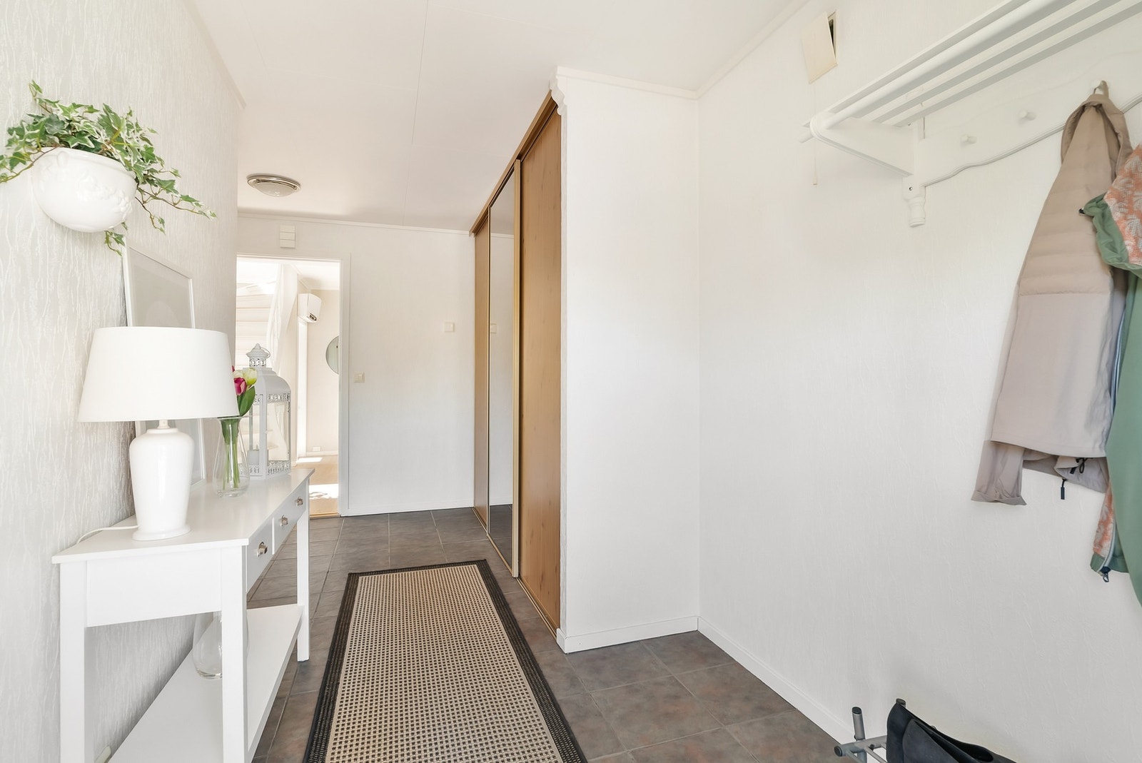 Romslig gang med god plass for å sette fra seg sko og henge fra seg klærne. Her er det varmekabler i gulv og skyvedørsgarderobe Galleribilde