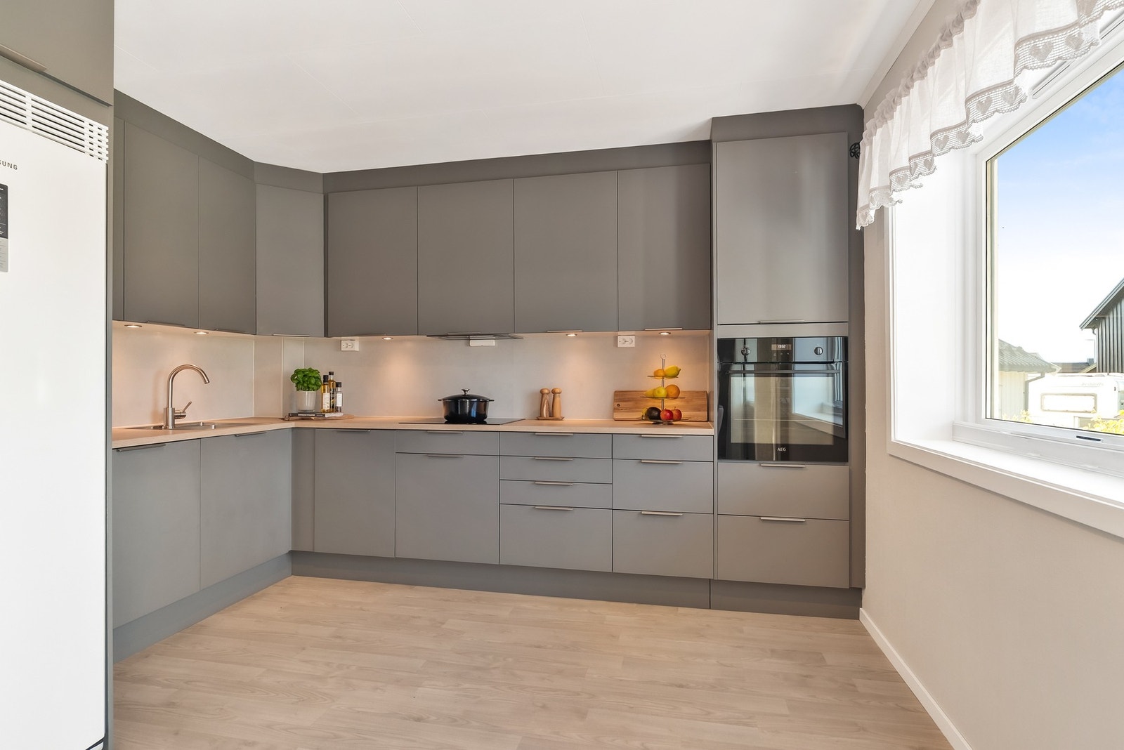 Kjøkkenet er tidløst og innbenynde - godt utbygget med skap- og benkeplass Galleribilde