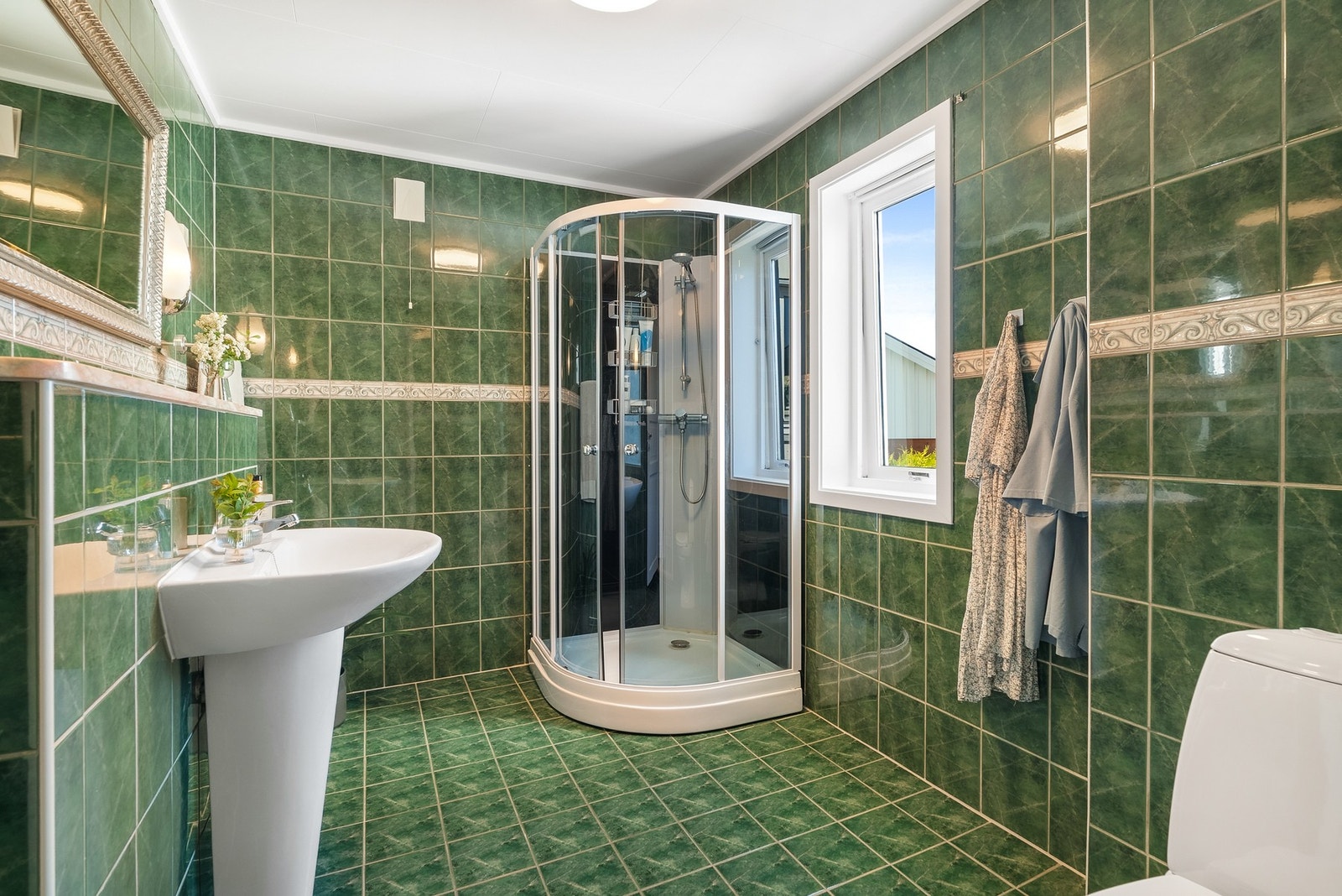 Badet er flislagt på gulv og vegger med varmekabler i gulv. Galleribilde