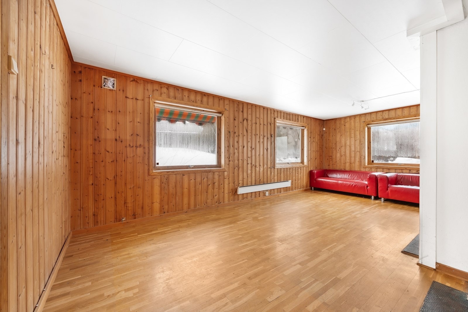 Romslig stue med plass til flere sittegrupper. Galleribilde