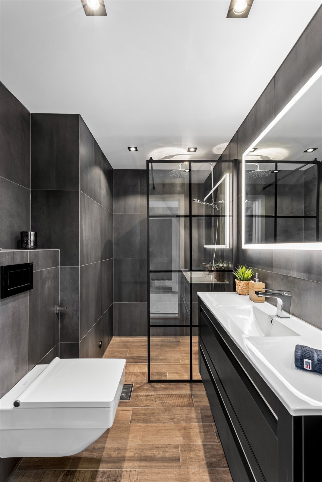 Leilighetens andre bad har dusj, servant med skuffer, speil og vegghengt wc. Galleribilde