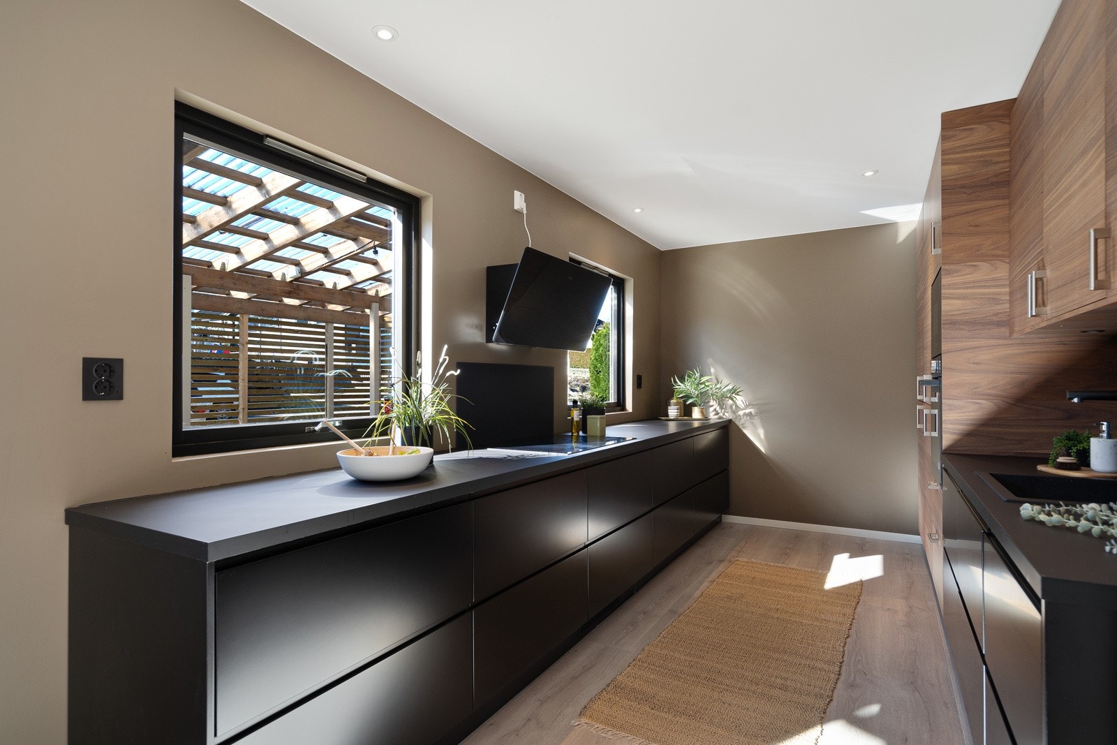 Kjøkkenet er stilrent og moderne, med sorte fronter, god skap- og benkeplass samt integrerte hvitevarer Galleribilde