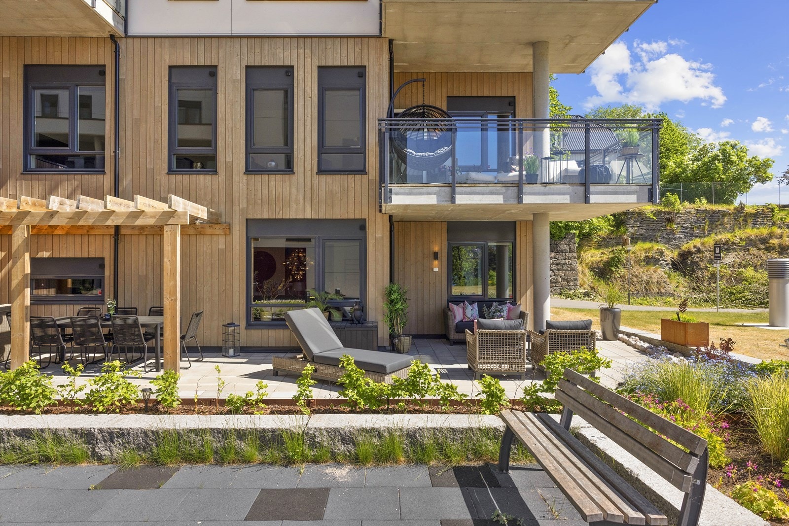 Spisestuen er plassert under hyggelig pergola og fremstår som en lun sone på dette flotte uterommet Galleribilde