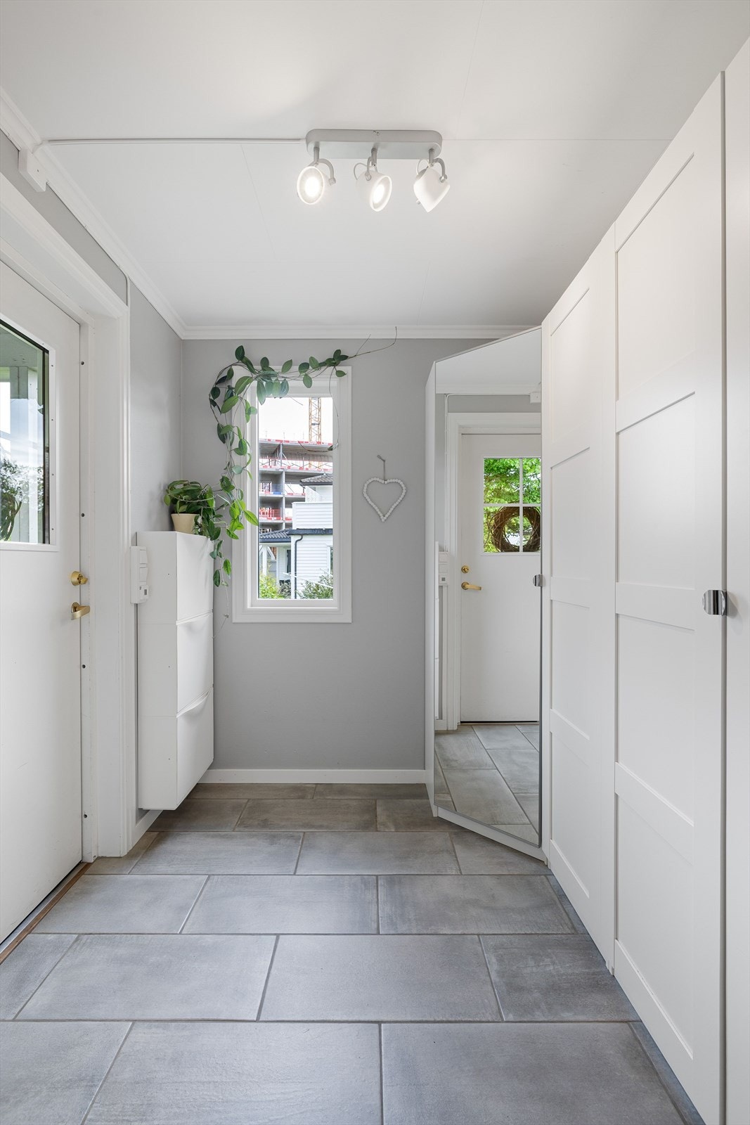 Du ønskes velkommen inn i en felles entré med flislagt gulv. I entréen er det god oppbevaringsplass i flere garderobeskap, samt ytterligere plass til sko i vegghengt skoskap. Galleribilde