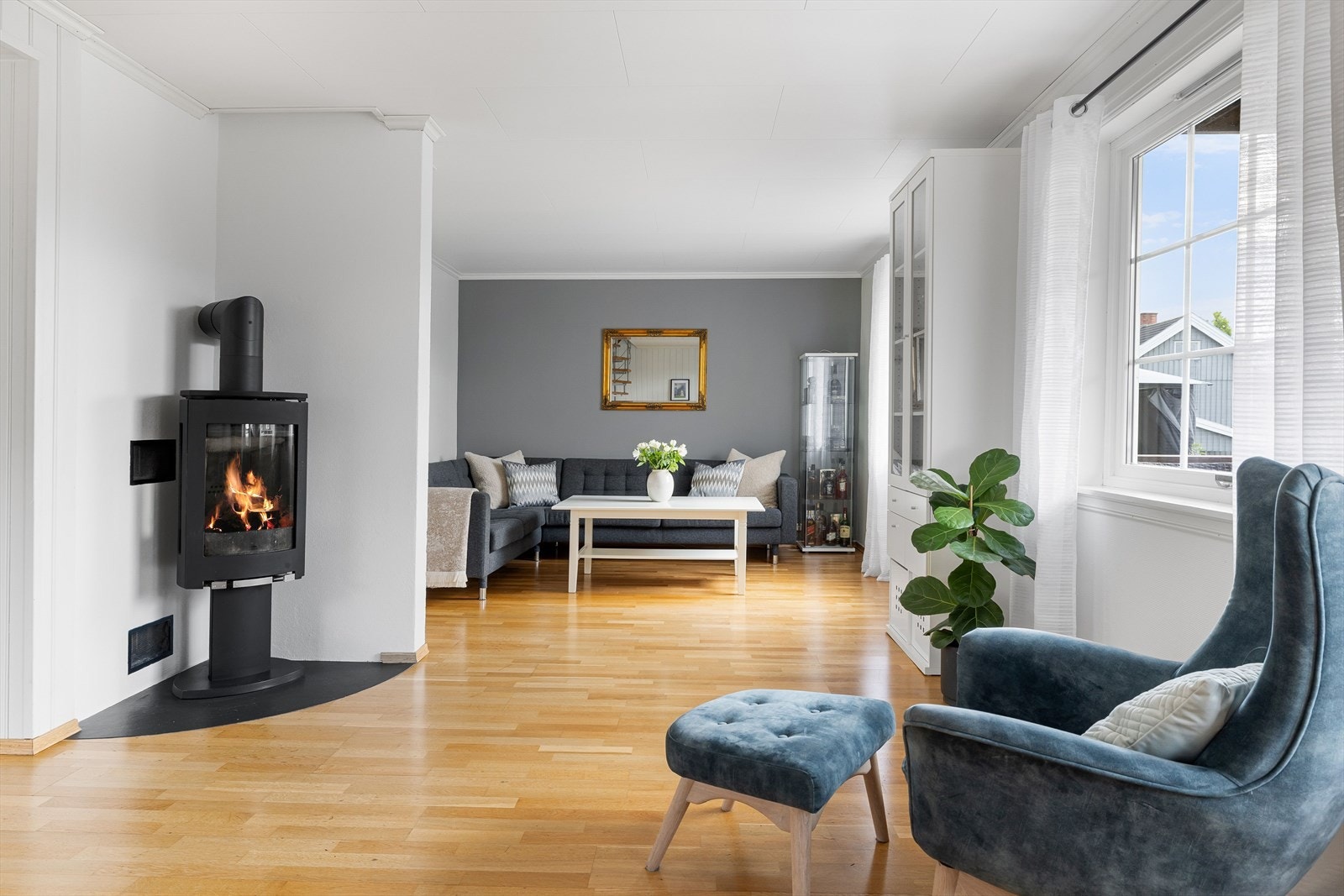 I hjørnet av stuen er det en moderne vedovn som både gir god varme og bidrar til ekstra hygge. Galleribilde