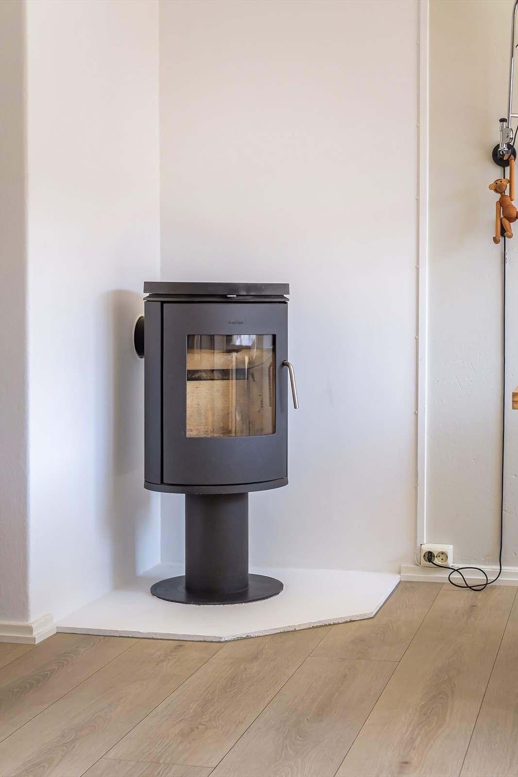 Midt i rommet er en stilfull vedovn som ikke bare gir ekstra varme, men også skaper en lun og koselig stemning Galleribilde