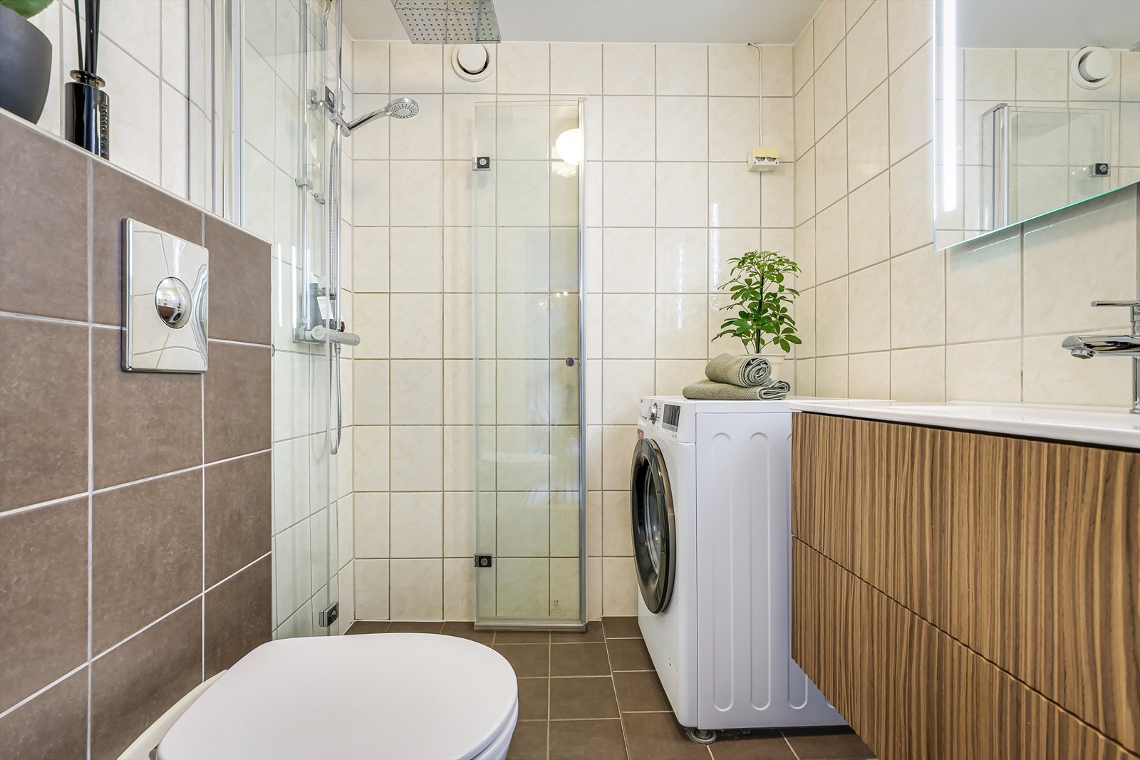 Flislagt bad med elektrisk gulvvarme og opplegg for vaskemaskin Galleribilde