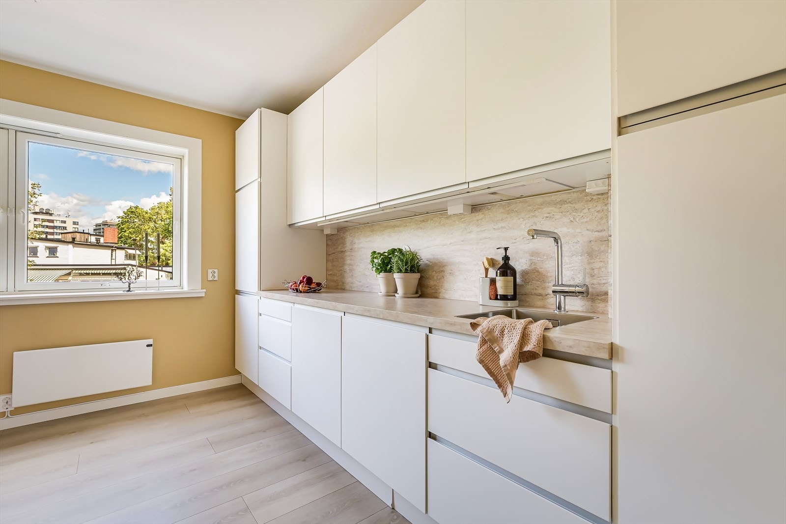 Det stilige IKEA-kjøkkenet fra 2011 har hvite, glatte fronter, laminert benkeplate og integrerte hvitevarer Galleribilde