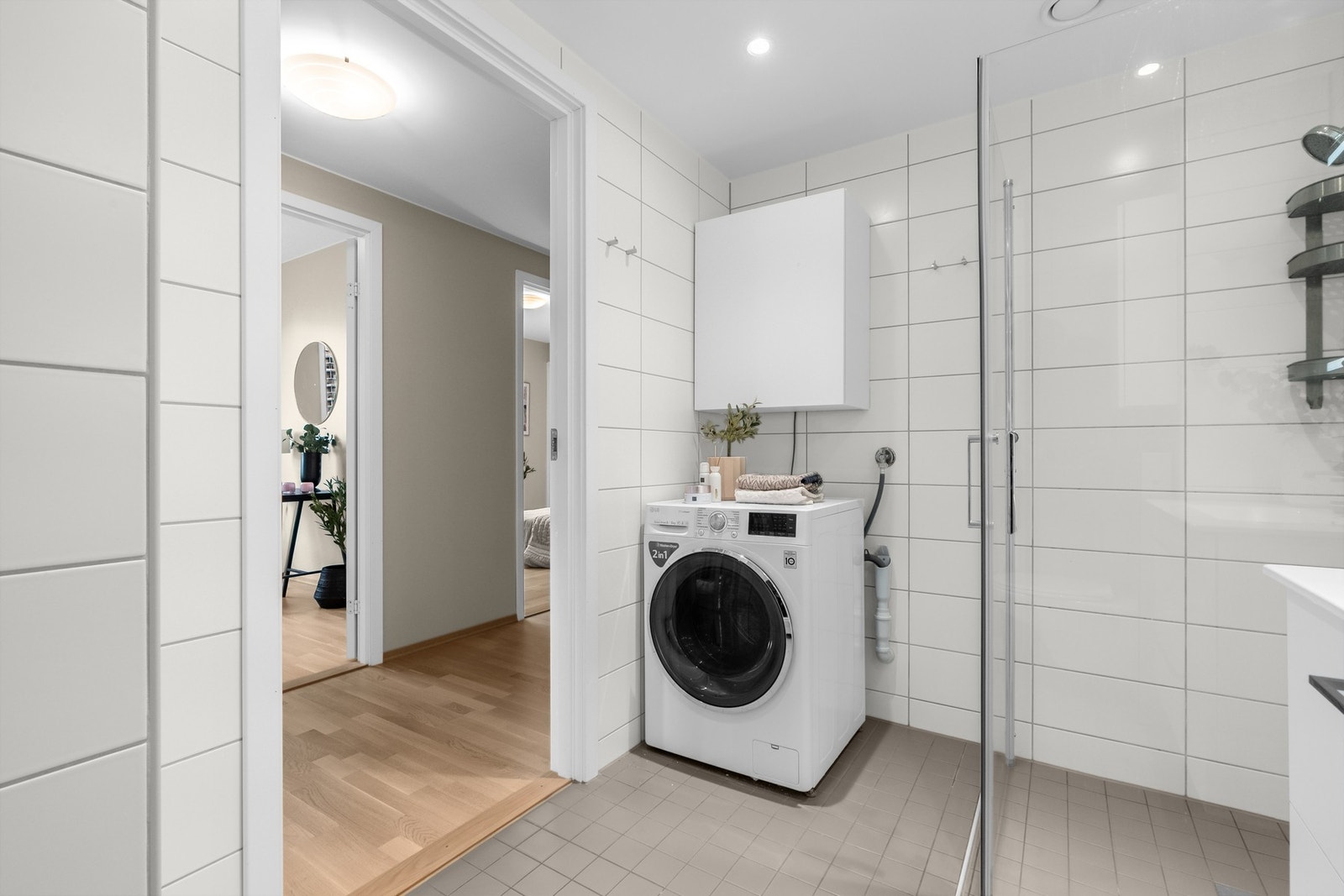 Hovedbadet har også pent flisvalg, gulvvarme, downlights og opplegg for vaskemaskin Galleribilde