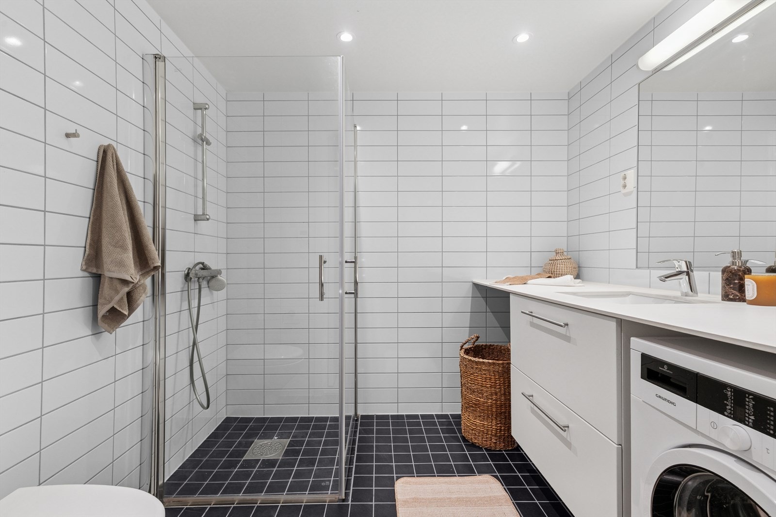 Flislagt bad med gulvvarme og opplegg for vaskemaskin og tørketrommel Galleribilde