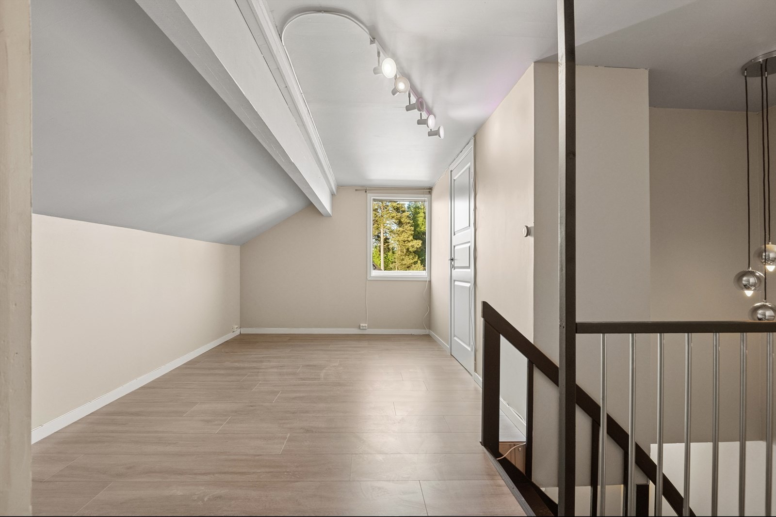 Lys og innbydende loftsstue med skråtak og vindu som gir flott utsyn og godt med dagslys - perfekt som ekstra oppholdsrom, kontor eller lekeområde. Galleribilde