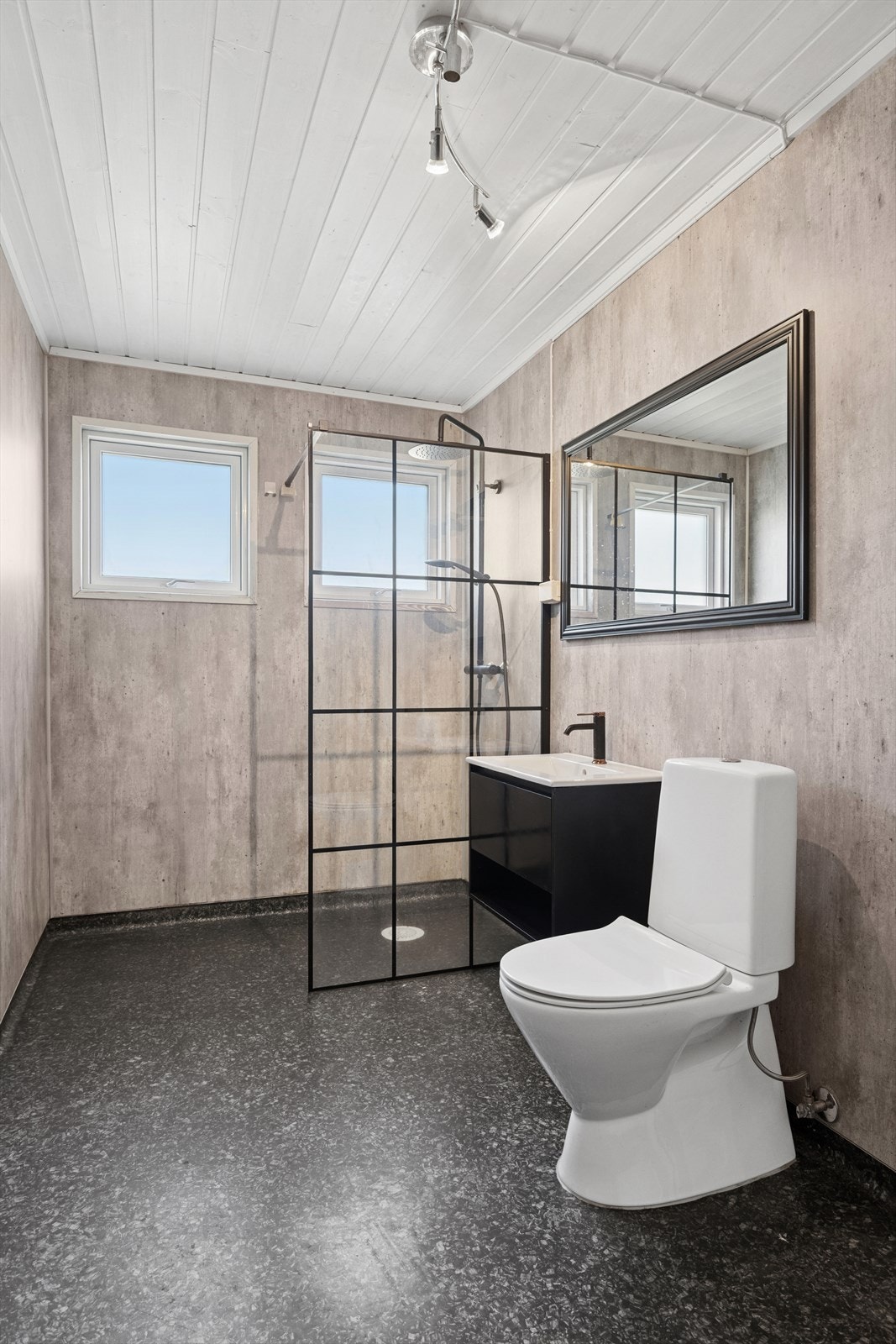 tilrent baderom med moderne uttrykk, dusjhjørne med glassvegg og godt med naturlig lys fra to vinduer. Galleribilde
