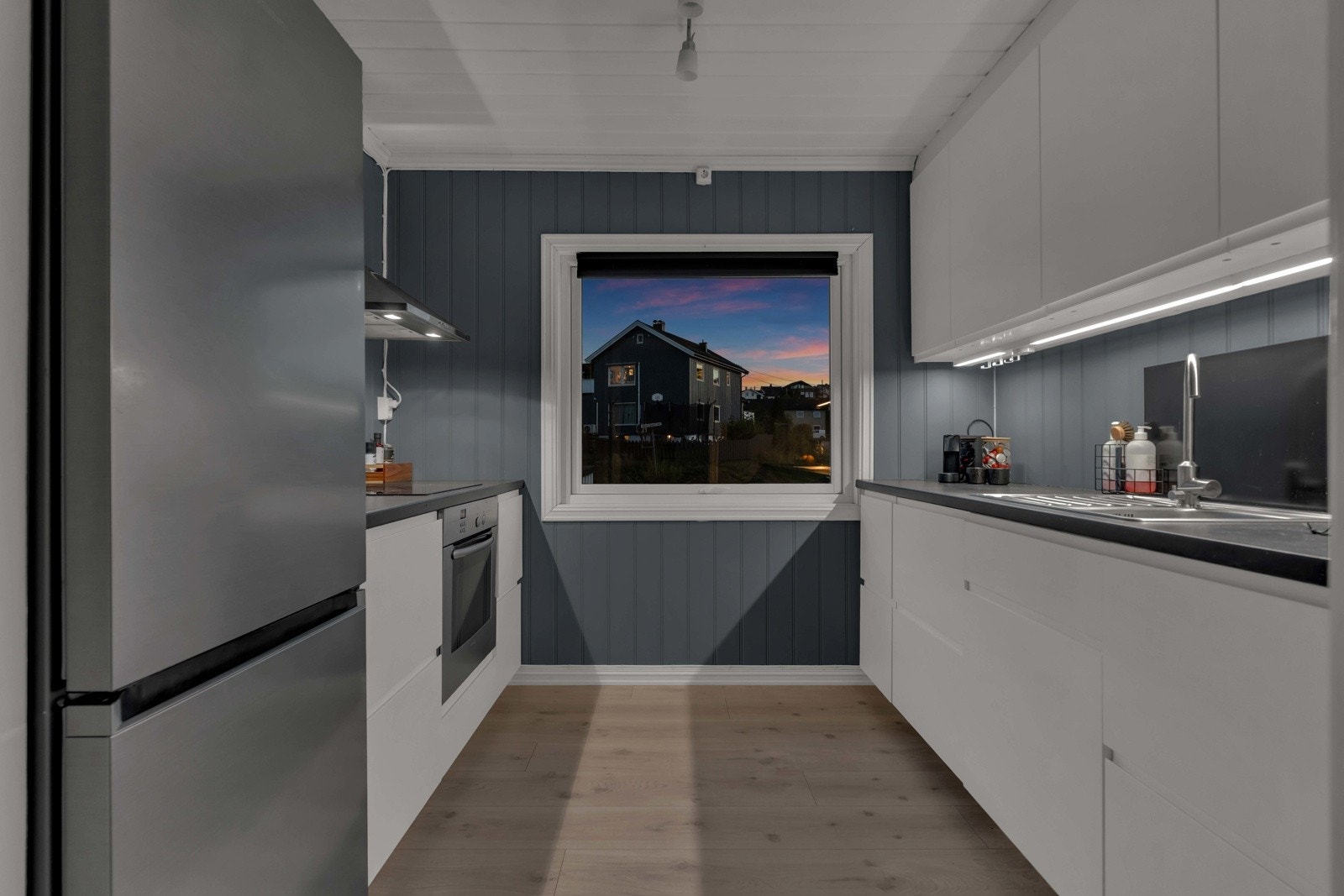 Kjøkkenet er separat og har en stilren innredning med glatte, moderne fronter og benkeplate i laminat Galleribilde
