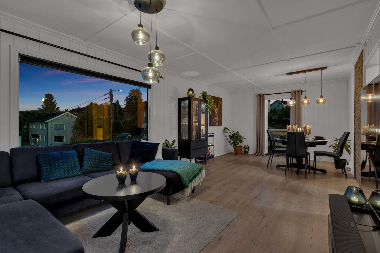 Stuen deles naturlig opp med egen sone for sofahjørne og spisetue på andre siden Galleribilde