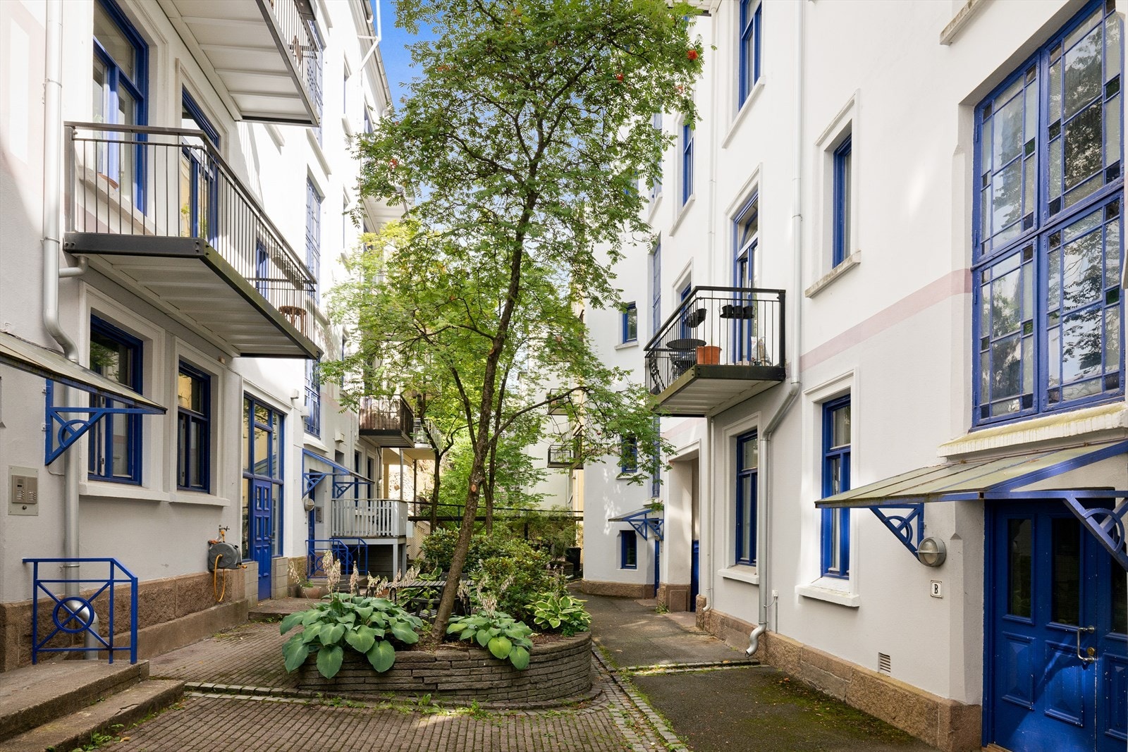 Lukket indre gård med brostein og vakker beplantning Galleribilde