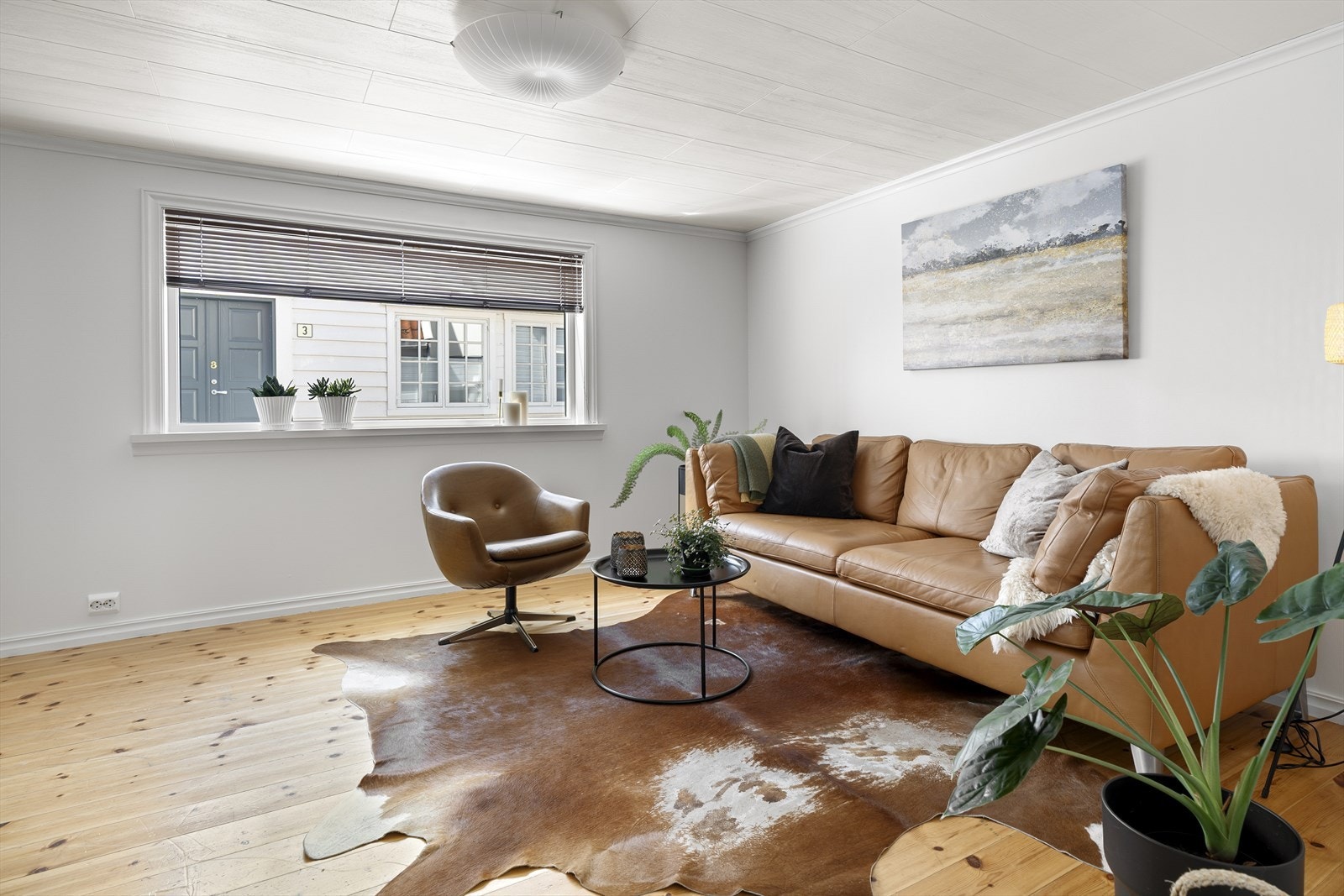 Stuen, mellomgang og kjøkken har furugulv og lyse vegger. Galleribilde