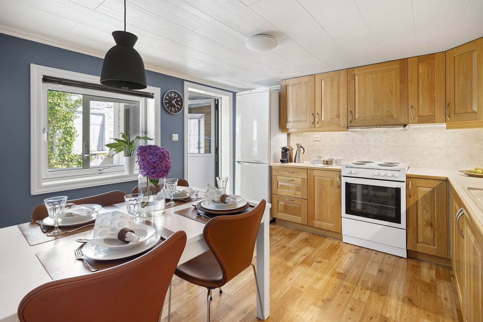 Tidløst kjøkken med profilerte eikefronter og benkeplate i laminat med treinnramming. Galleribilde