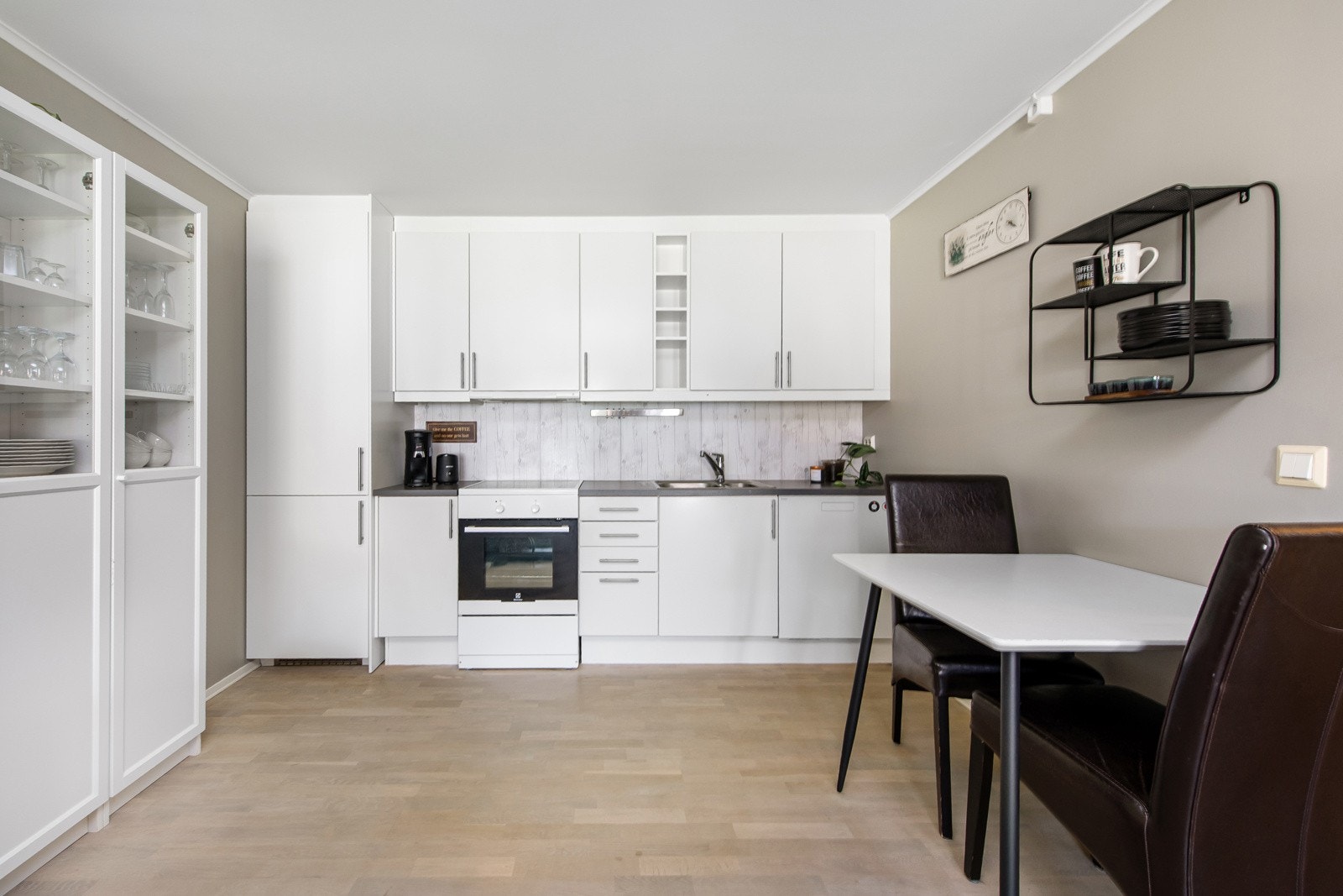 Kjøkkeninnredning av glatte hvite fronter og laminert benkeplate. Galleribilde