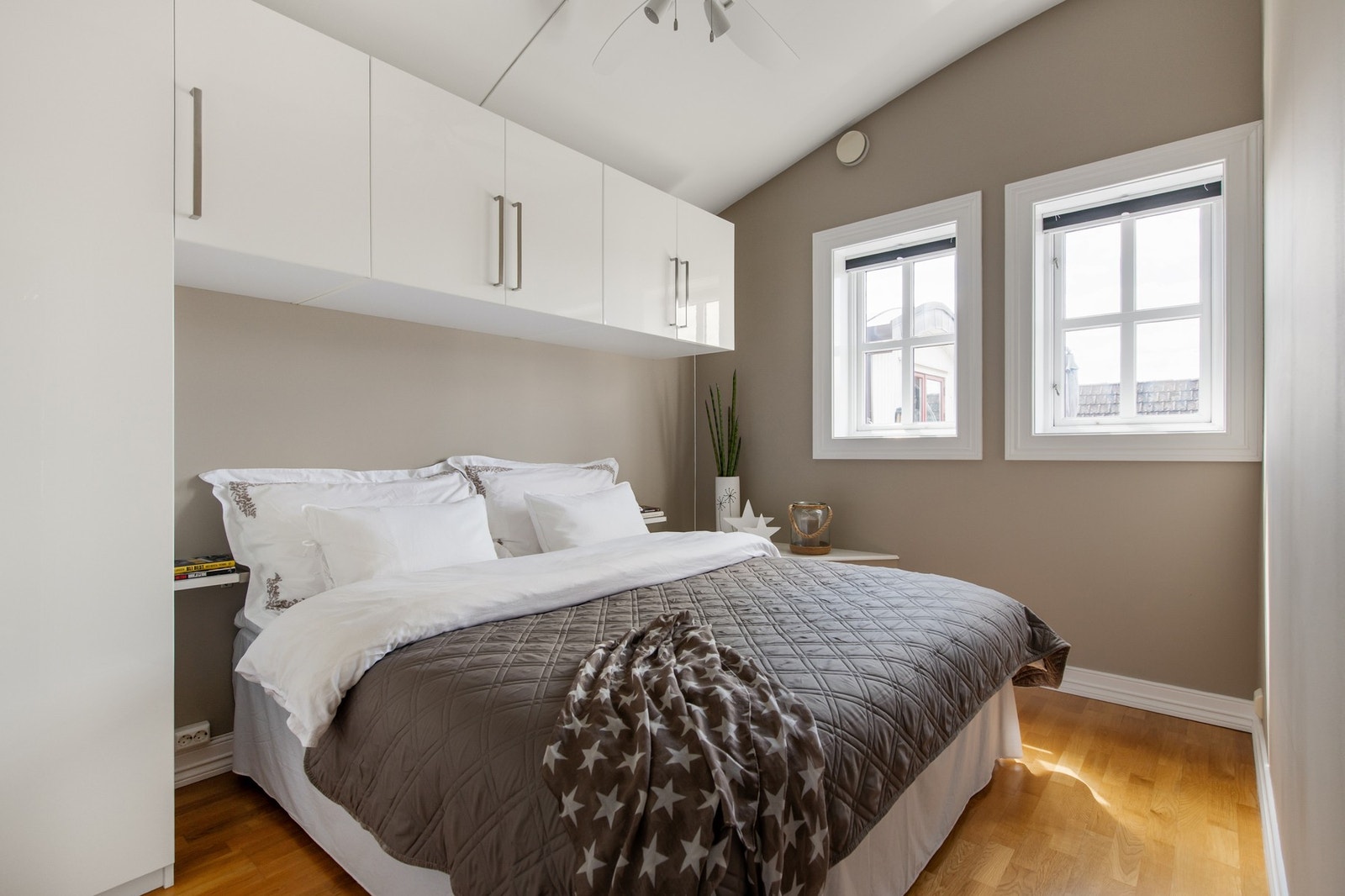 To pene soverom ligger vegg i vegg på øverste plan. På hovedsoverommet er hvite skap montert over og ved siden av den avsatte plassen for dobbeltseng. Galleribilde