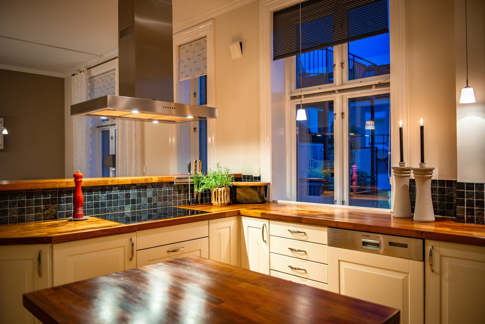 Selve innredningen har hvite, profilerte fronter. Sorte fliser er montert over benken, og over kokesonen har kjøkkenet en takhengt ventilator. Galleribilde