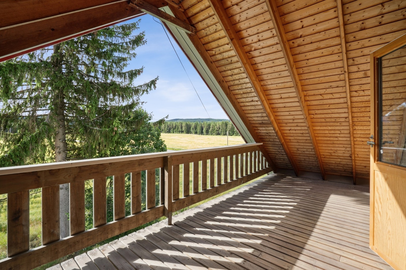 Balkongen er bygget i solid trekonstruksjon med rekkverk av tre og har gulv belagt med klassiske terrassebord. Galleribilde