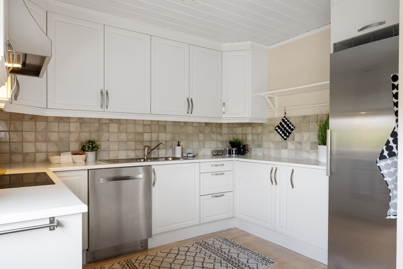 Egen plass og opplegg for kjøl-/fryseskap ved tidligere kjølehjørnet. Fliser på vegg mellom benkeplate og overskap. Det er montert komfyrvakt over kokesone. Galleribilde