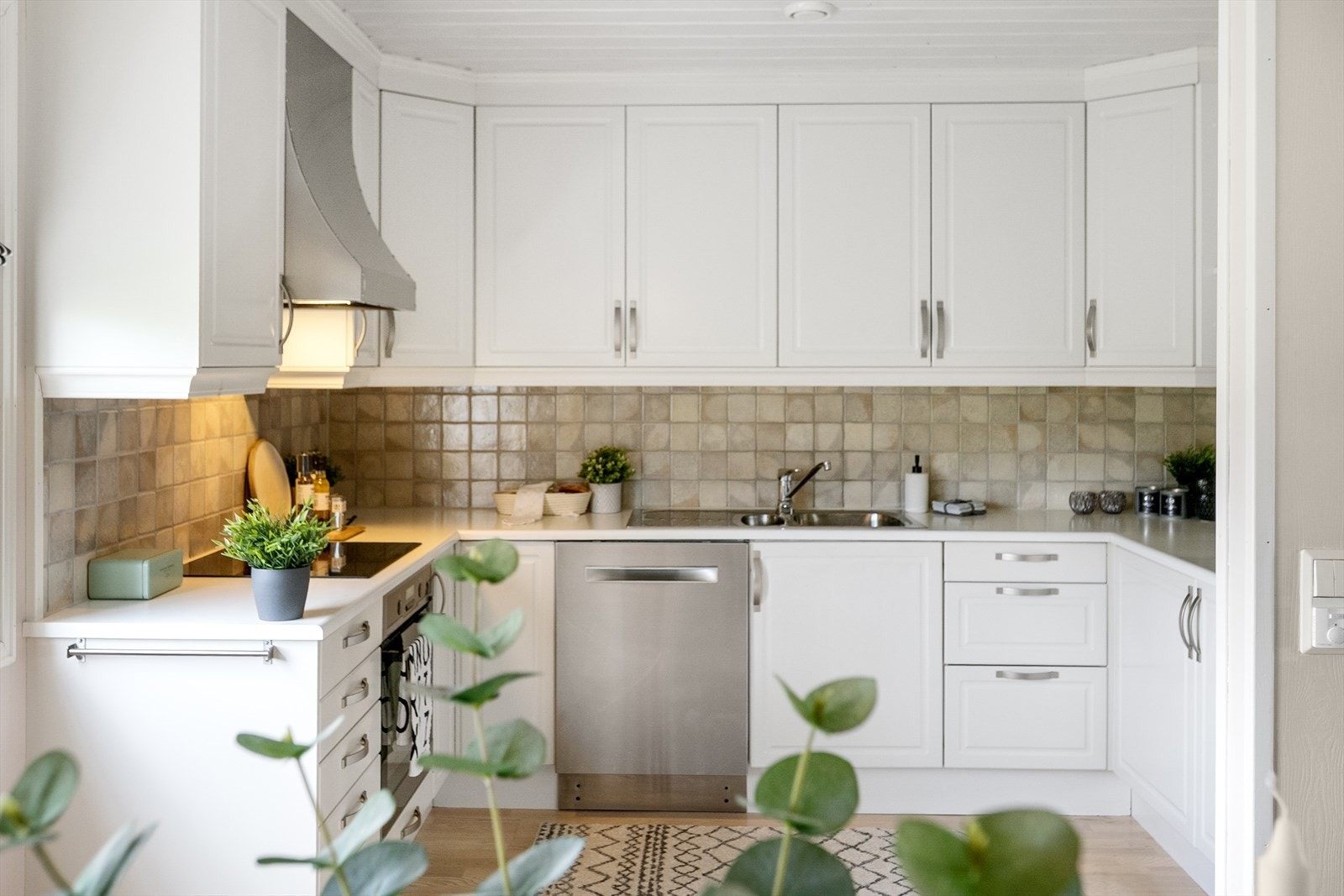 Lyst og pent kjøkken med glatte og profilerte fronter. Laminert benkeplate med nedfelt vaskekum og platetopp. Rikelig med skap- og benkeplass. Galleribilde