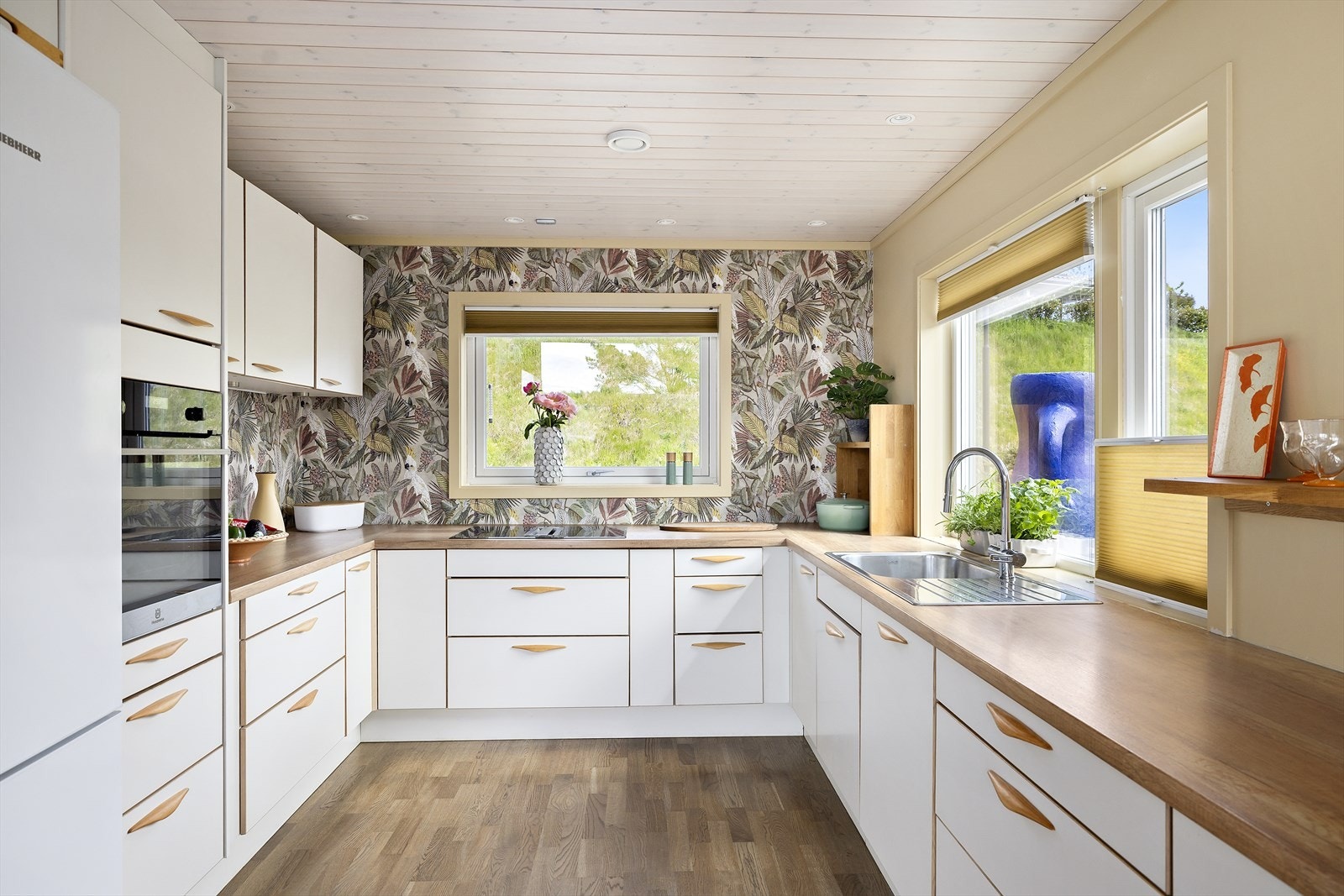 Det er montert plisségardiner i vinduene på kjøkkenet Galleribilde