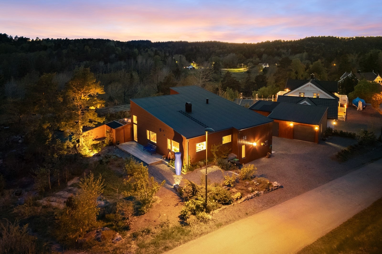 Denne eiendommen har en stor og pent opparbeidet hjørnetomt, med gruset innkjørsel, diverse beplantinger og noe naturlig vegetasjon. Galleribilde