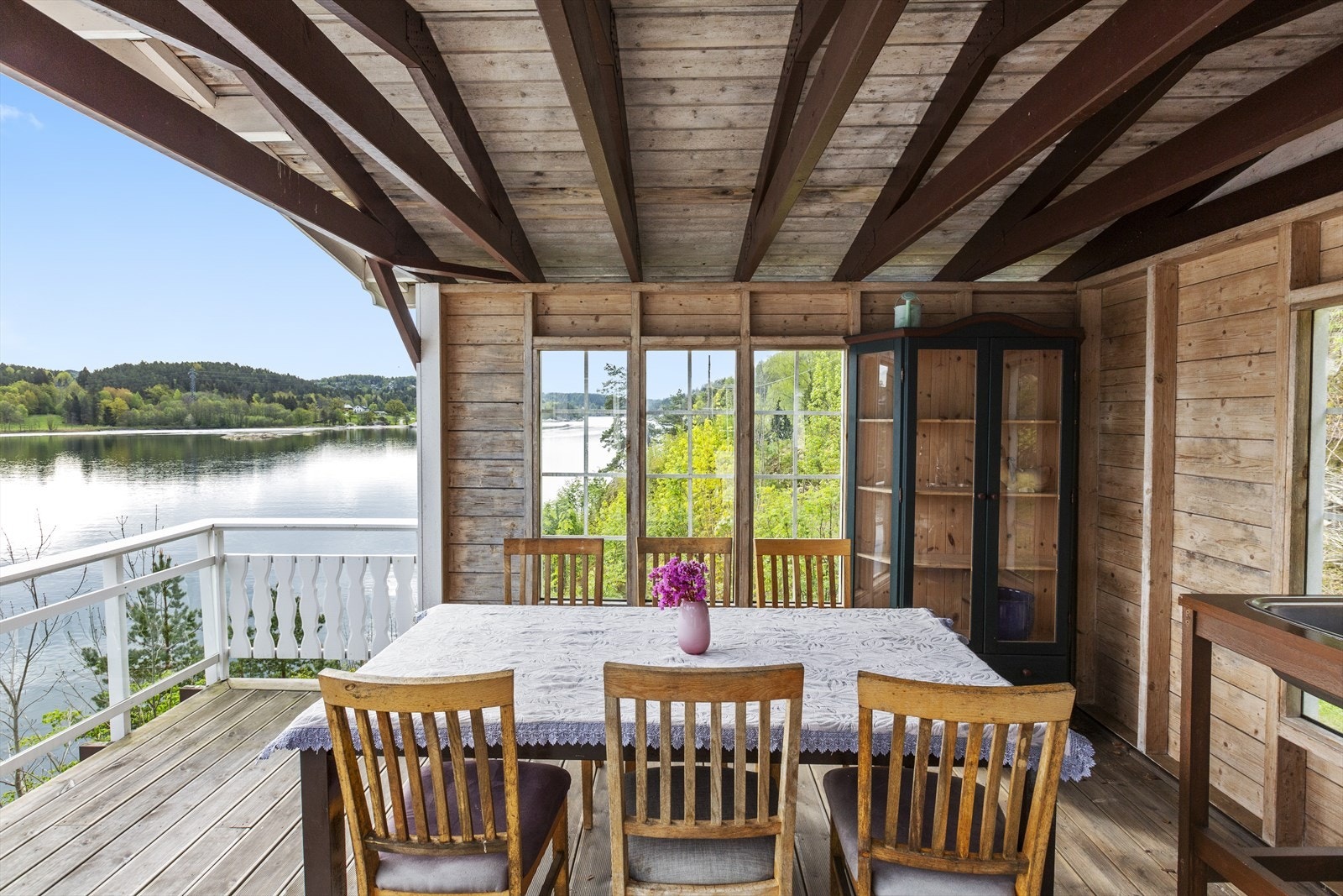 Overbygd uteplass med spisebord og plass til gjester. Galleribilde