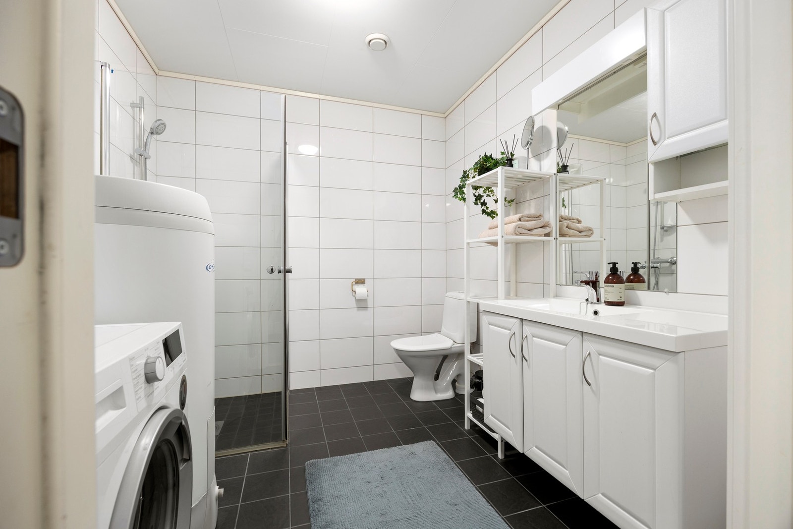 Bad - 5,5 kvm. Utstyrt med servantskap, dusjdører, toalett og opplegg for vaskemaskin Galleribilde