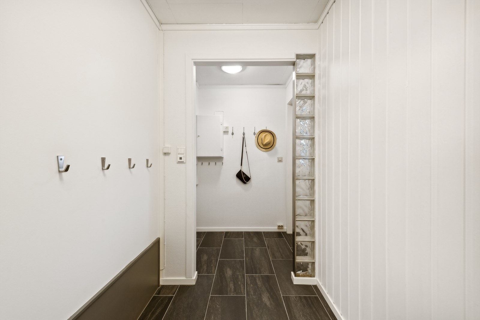 Man ønskes velkommen i en flislagt entré/vindfang. Galleribilde