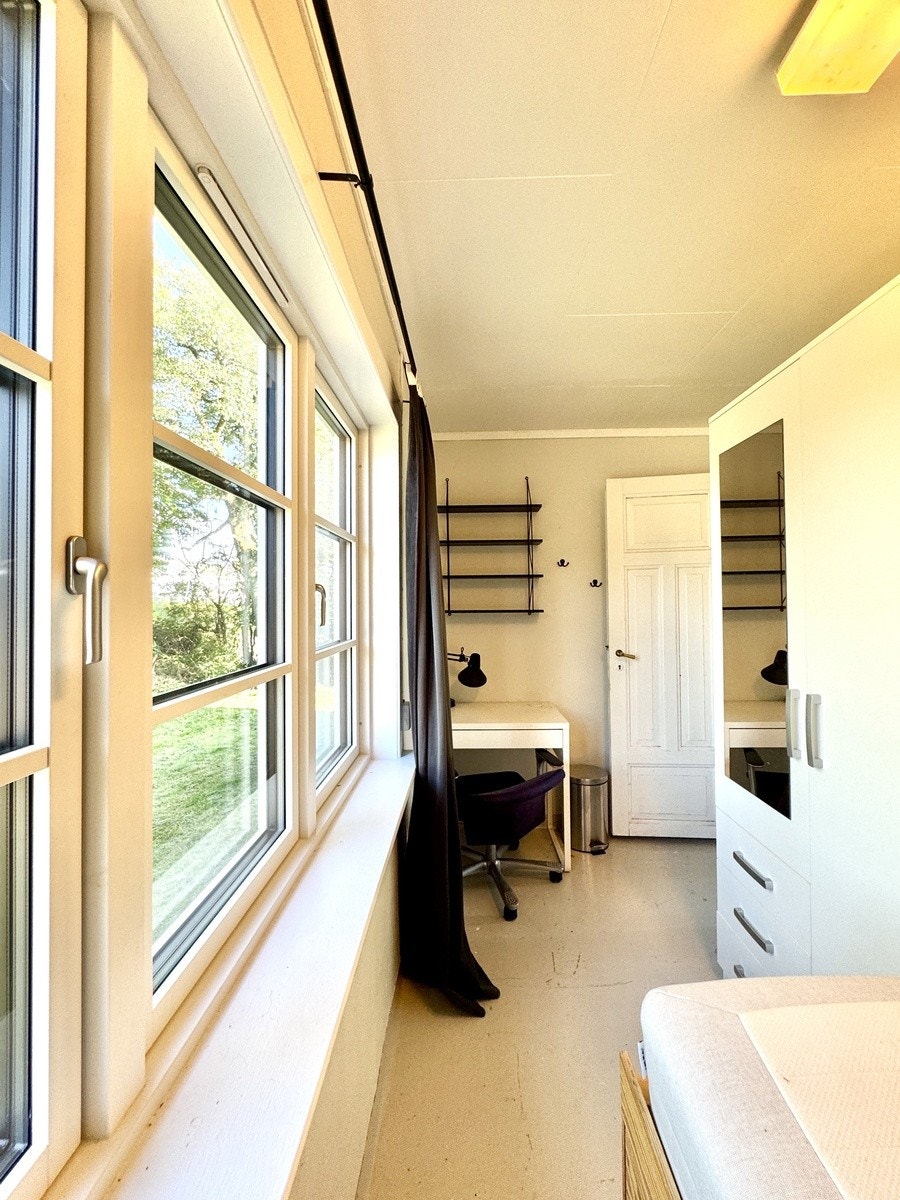 Store, lyse vinduer med luftespalte og lydglass. Lite skrivebord. Mulig med noe større skrivebord plassert mot utevegg. Galleribilde