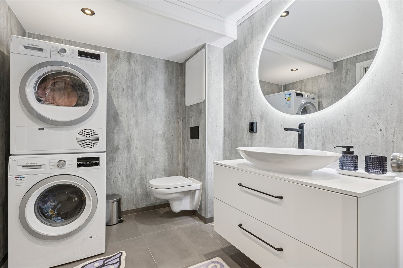 Flis på gulv, sokkelflis, våtromsplater på vegg og plater i himling. Dusjvegger av glass og dusjgarnityr på vegg, vegghengt toalett. Det er etablert plastsluk i dusjsonen. Det er etablert mekanisk avtrekk via bryter på vegg Galleribilde