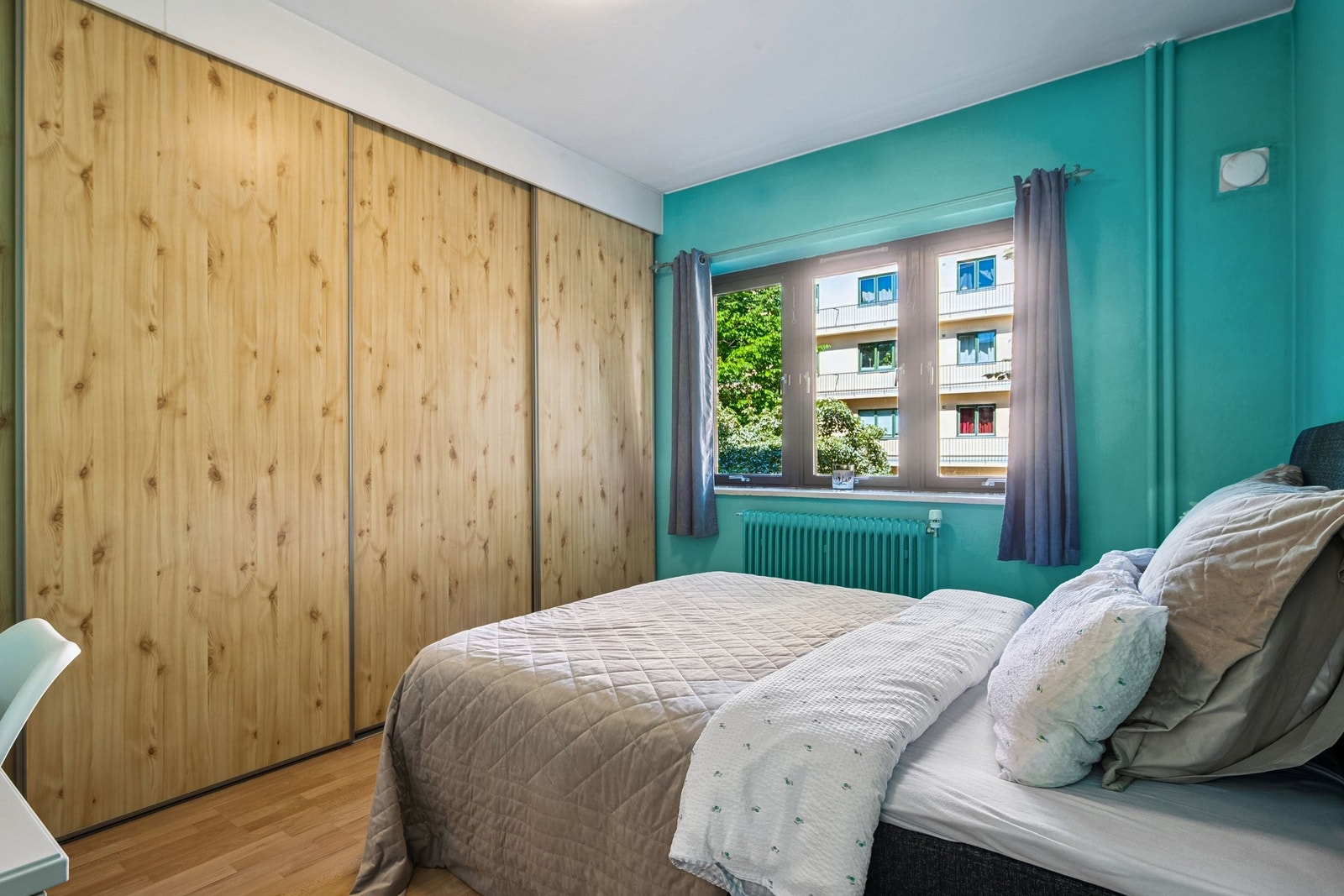 Romslig hovedsoverom nordøst i leiligheten med stor 4-dørers skyvedørsgarderobe og plass til både dobbeltseng og skrivebord! Galleribilde