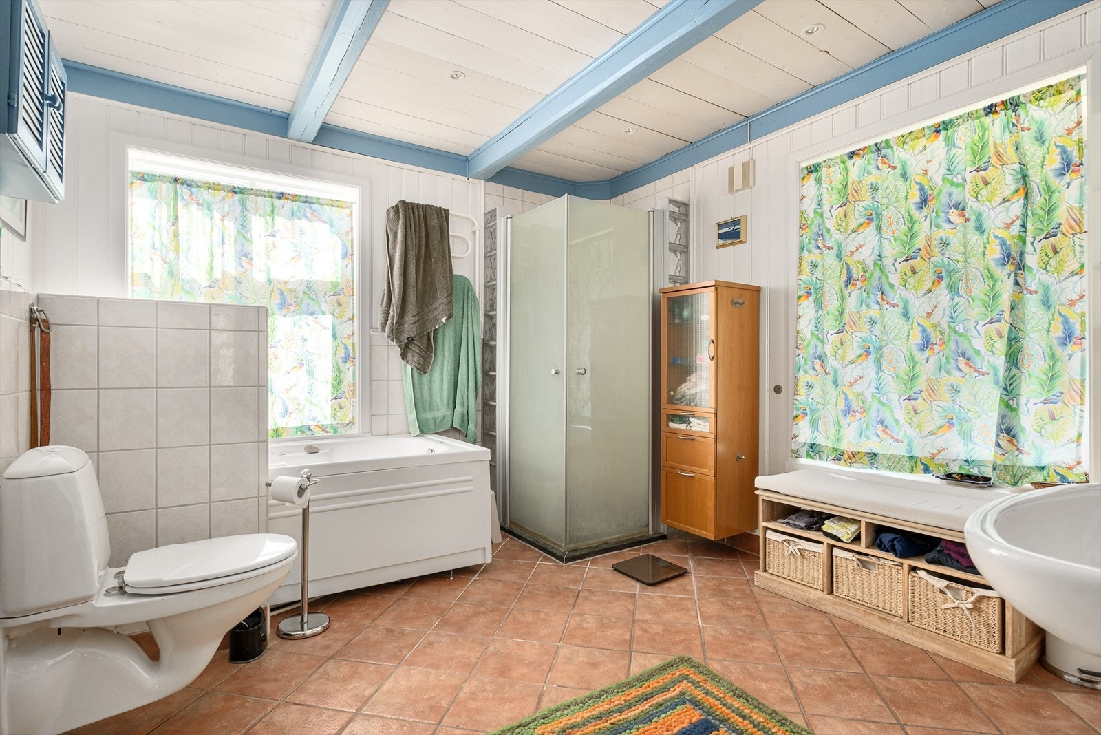 Flislagt bad med vegghengt toalett, badekar og dusjhjørne Galleribilde