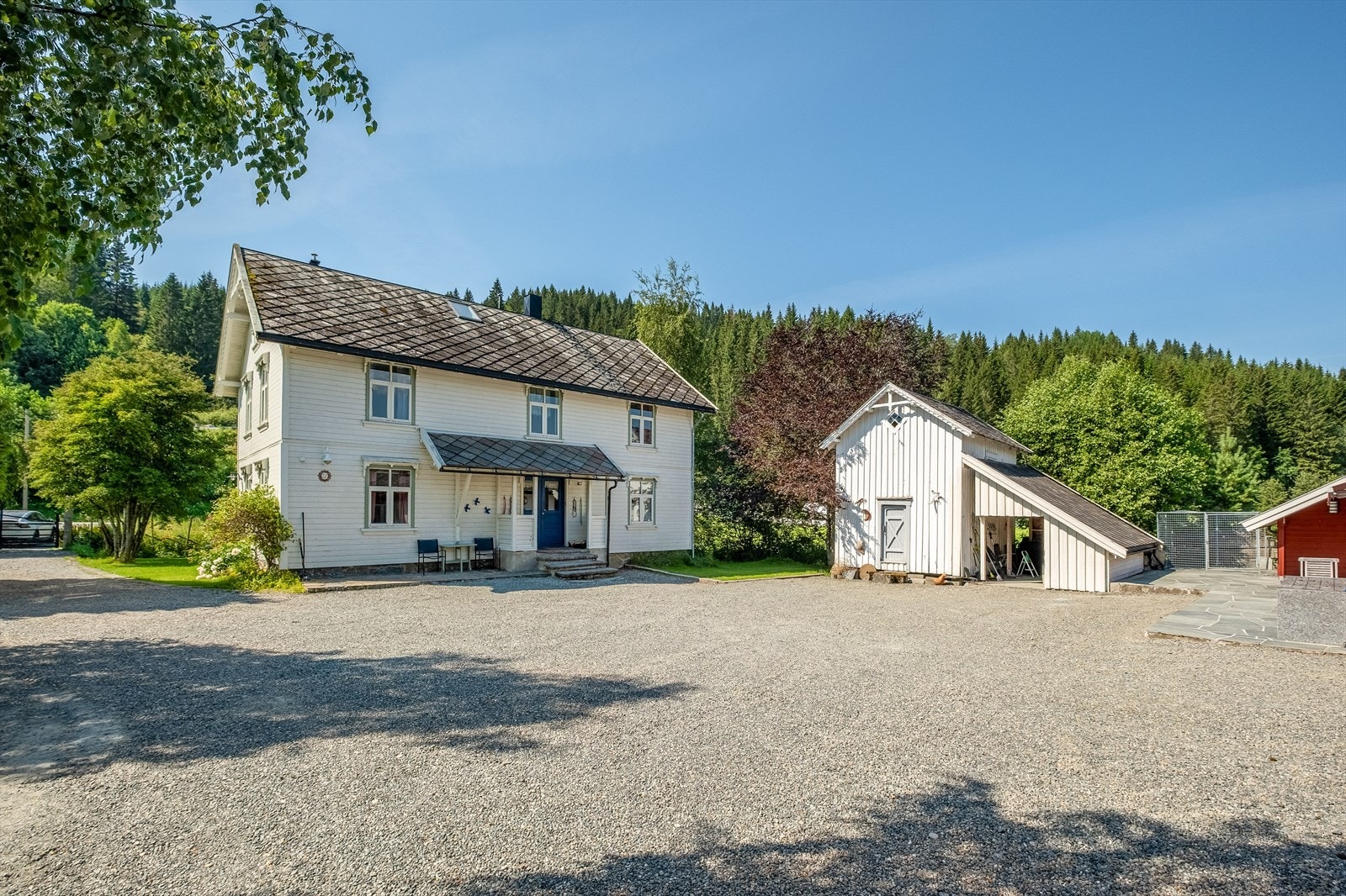 Koselig tun bestående av enebolig i tømmerkonstruksjon, stabbur, verksted/garasje og verksted Galleribilde