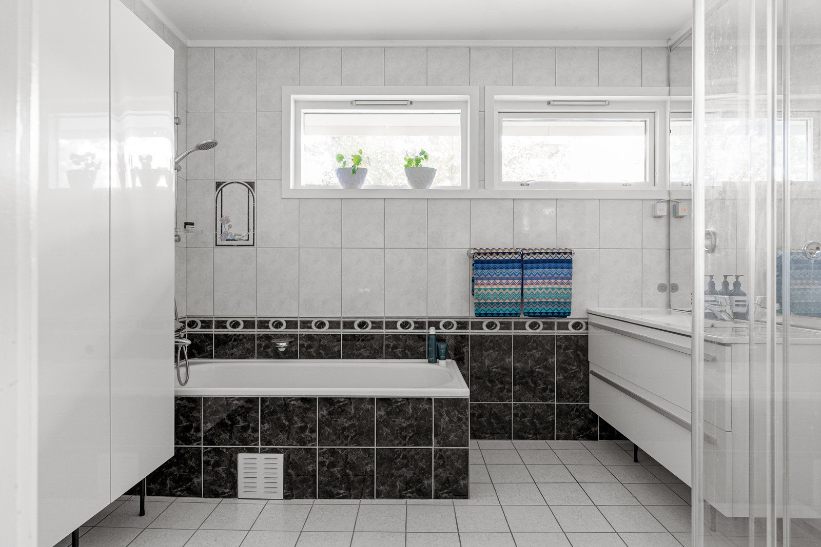 Stort baderom på hovedplan med badekar og dusj.