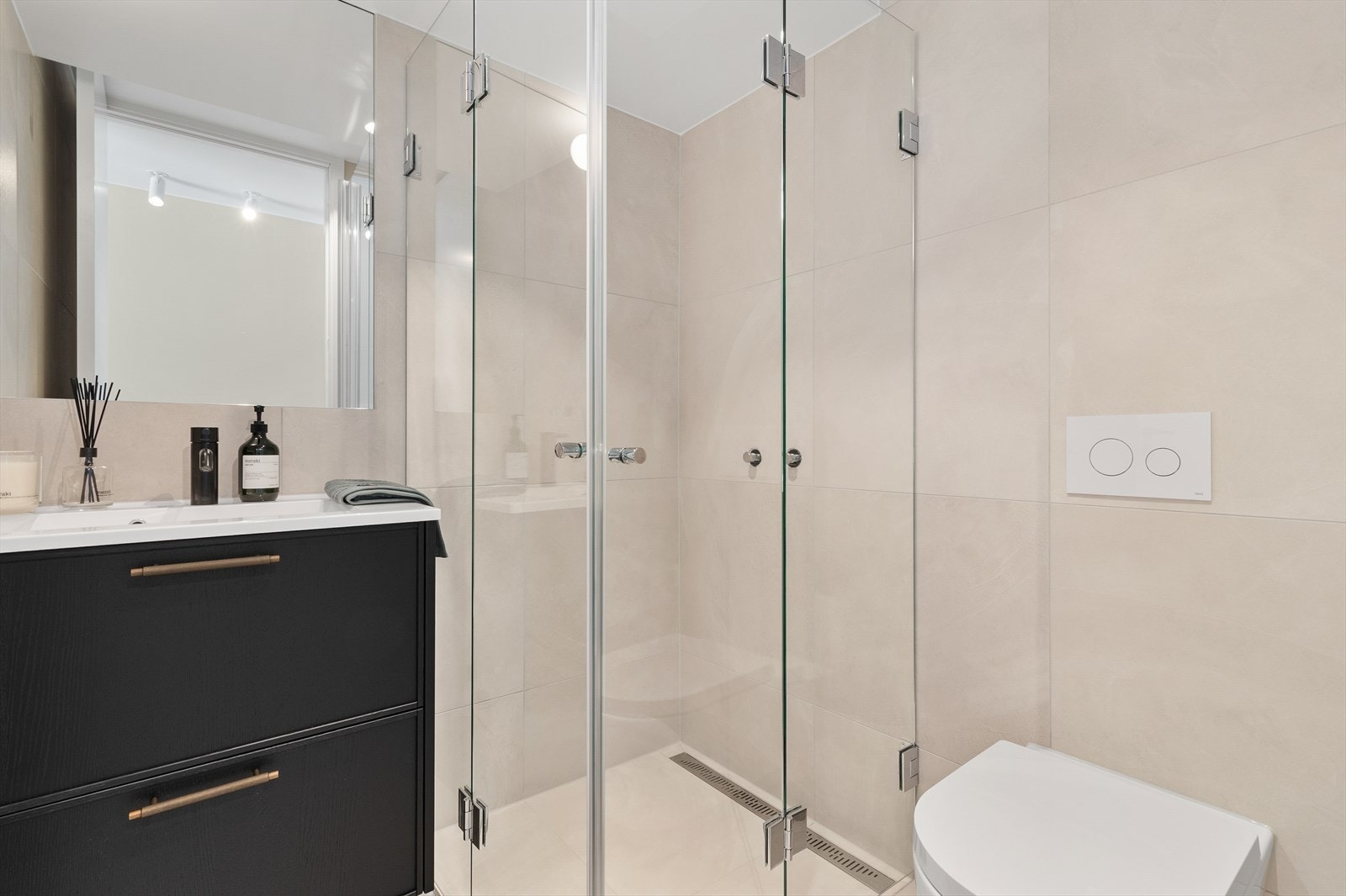 Bad II i 2. etasje er også helfliset baderom med innfelte downlights i himling og elektriske varmekabler i gulv. Innredningen er levert av Bekkestua Kjøkkenstudio. Galleribilde