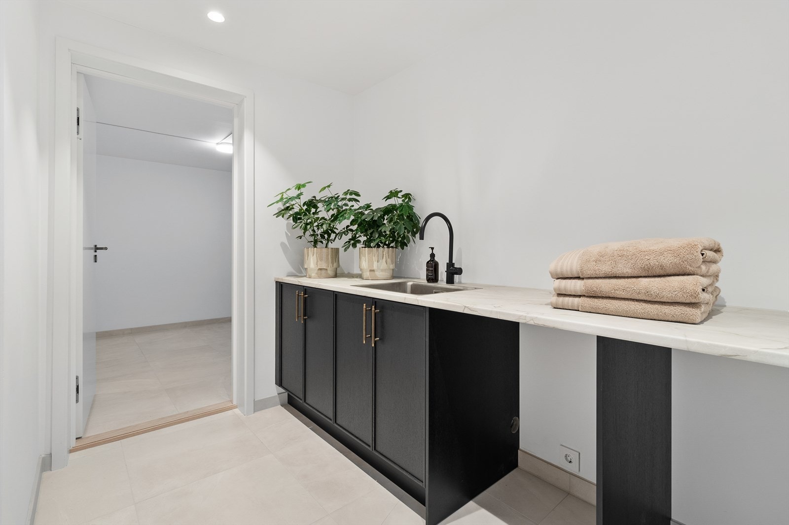 I kjelleren er det laget til med vaskerom, under benkeplaten er det avsatt plass til vaskemaskin og tørketrommel. Galleribilde