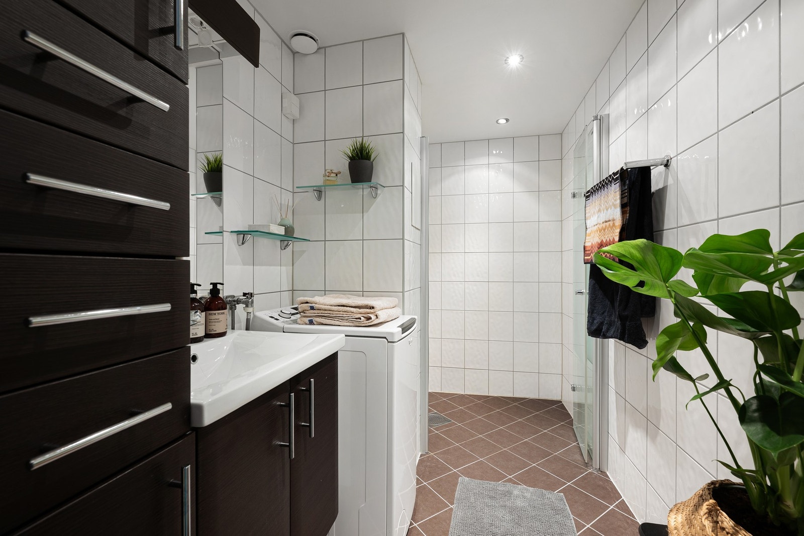 Flislagt bad med gulvvarme, tidløs innredning, downlights og opplegg for vaskemaskin. Galleribilde