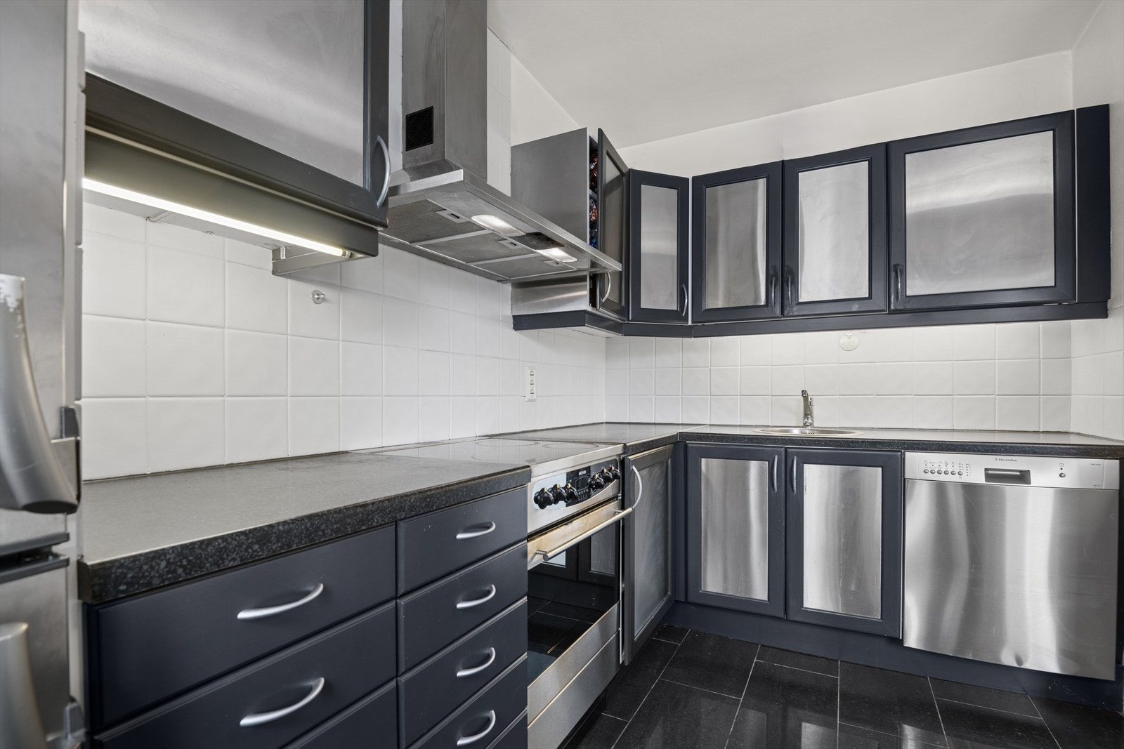 Kjøkkenet har frittstående kjøleskap, komfyr og oppvaskmaskin. Galleribilde