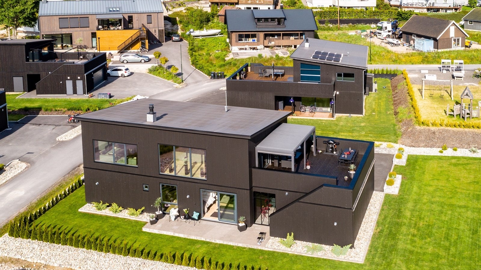 Solrik tomt med dobbelgarasje, pent opparbeidet hage, pergola og lune uteplasser. Galleribilde