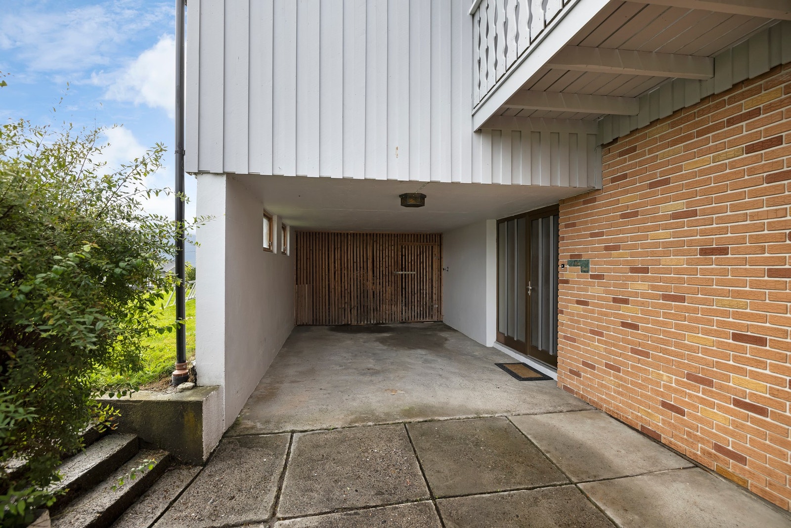 Parkering for én bil i carport like utenfor inngangspartiet. Galleribilde