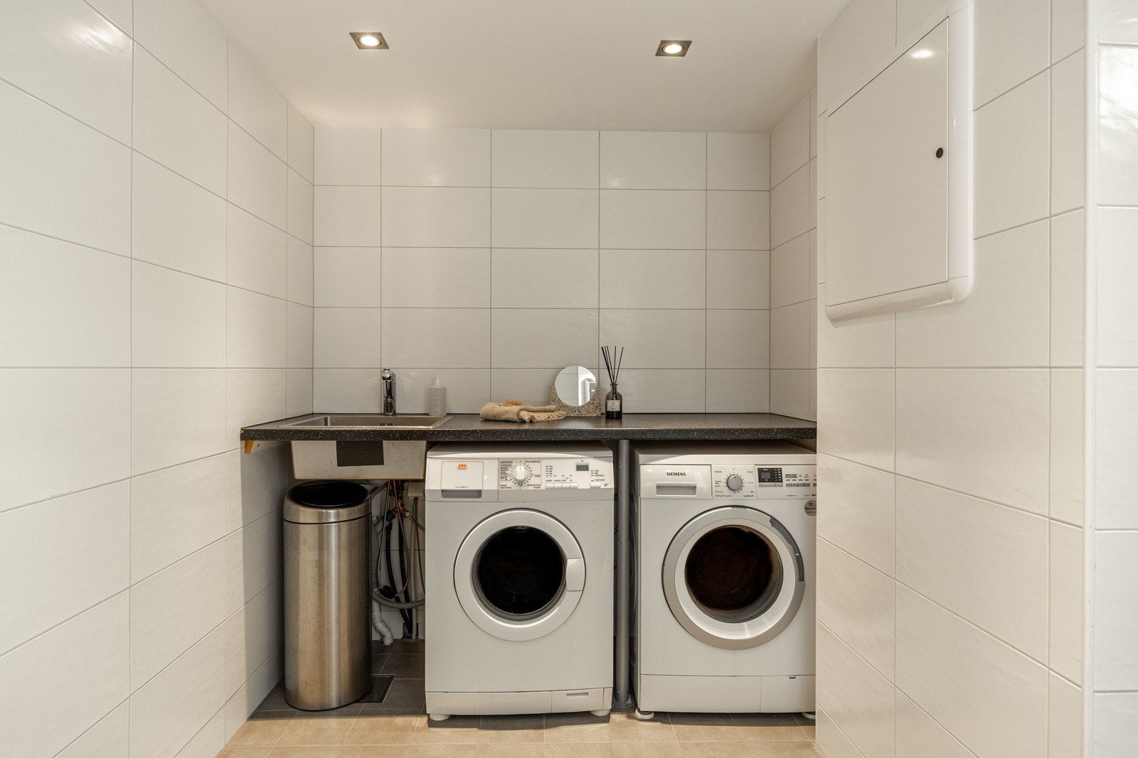 Opplegg for vaskemaskin og tørketrommel. Stoppeventiler plassert under servant og utslagsvask. Galleribilde